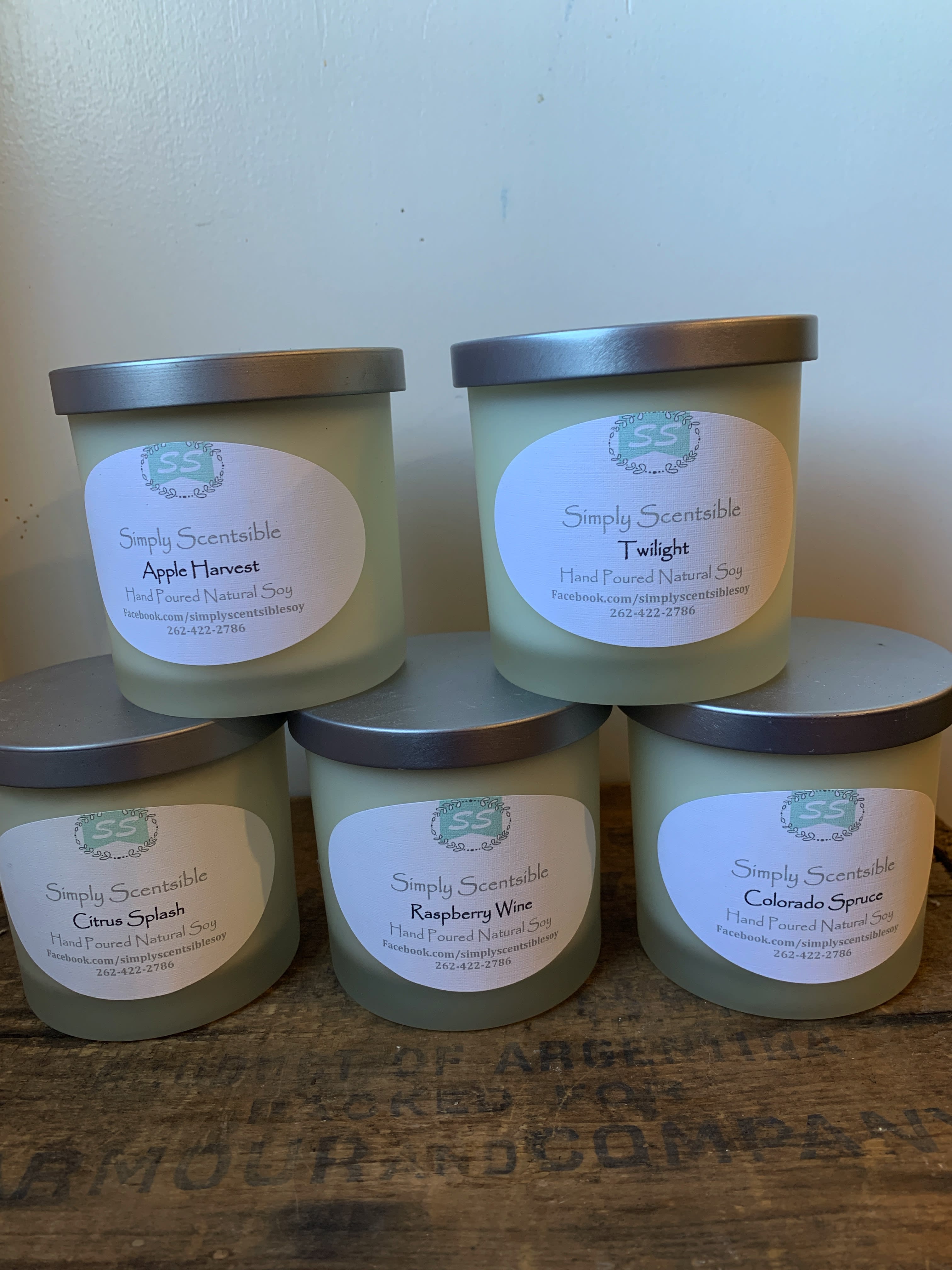 Five labeled soy candles in frosted glass jars with metal lids.