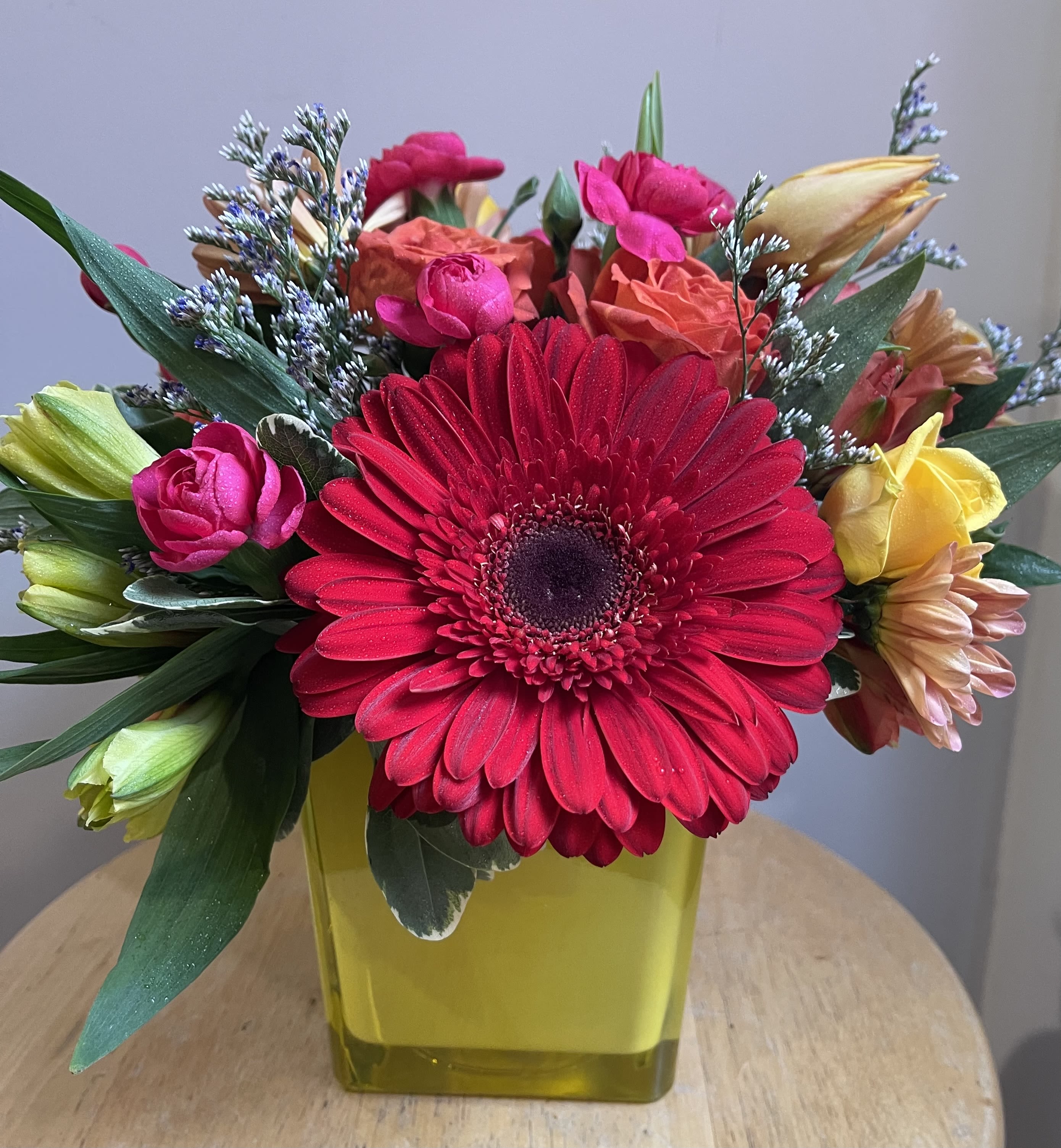 Bright mixed bouquet with a large red gerbera in a yellow vase