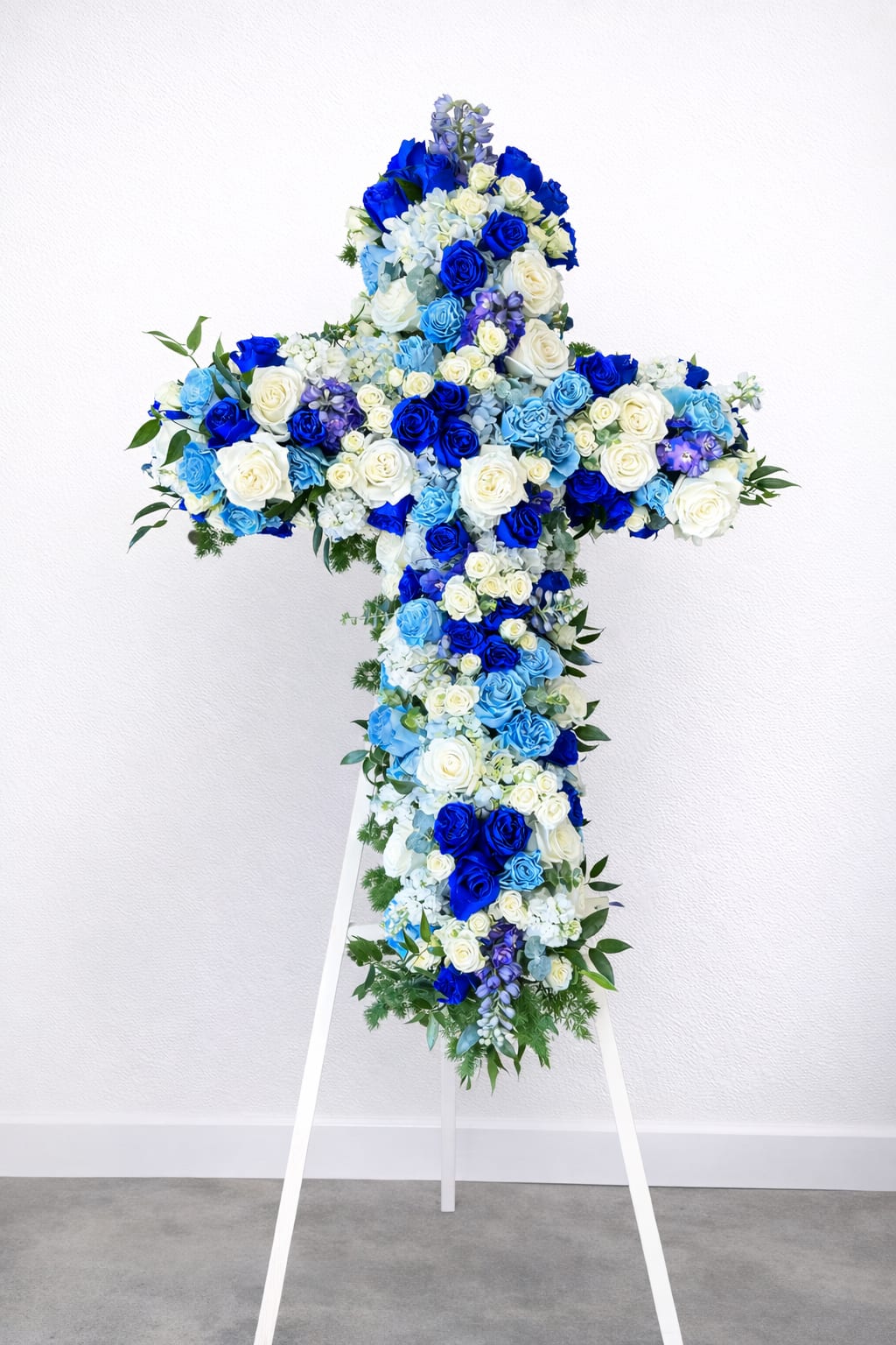 Blue and white floral cross on a white stand