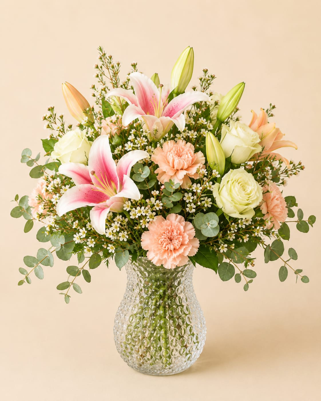 Full of Radiance  - This elegant floral arrangement features a refreshing blend of blooms, accented with delicate touches of pinks and lush greenery. Designed in a clear glass vase, the composition showcases premium flowers and seasonal fillers, and roses that are artfully enhanced with a soft blue floral tint for a beautifully cohesive look.  The gently tinted roses add a unique, modern touch while maintaining a natural, garden-inspired feel. Full of texture and airy movement, this arrangement brings a sense of calm and sophistication to any space.  Perfect for celebrations, its cool color palette makes it both timeless and versatile for any occasion or décor style.     