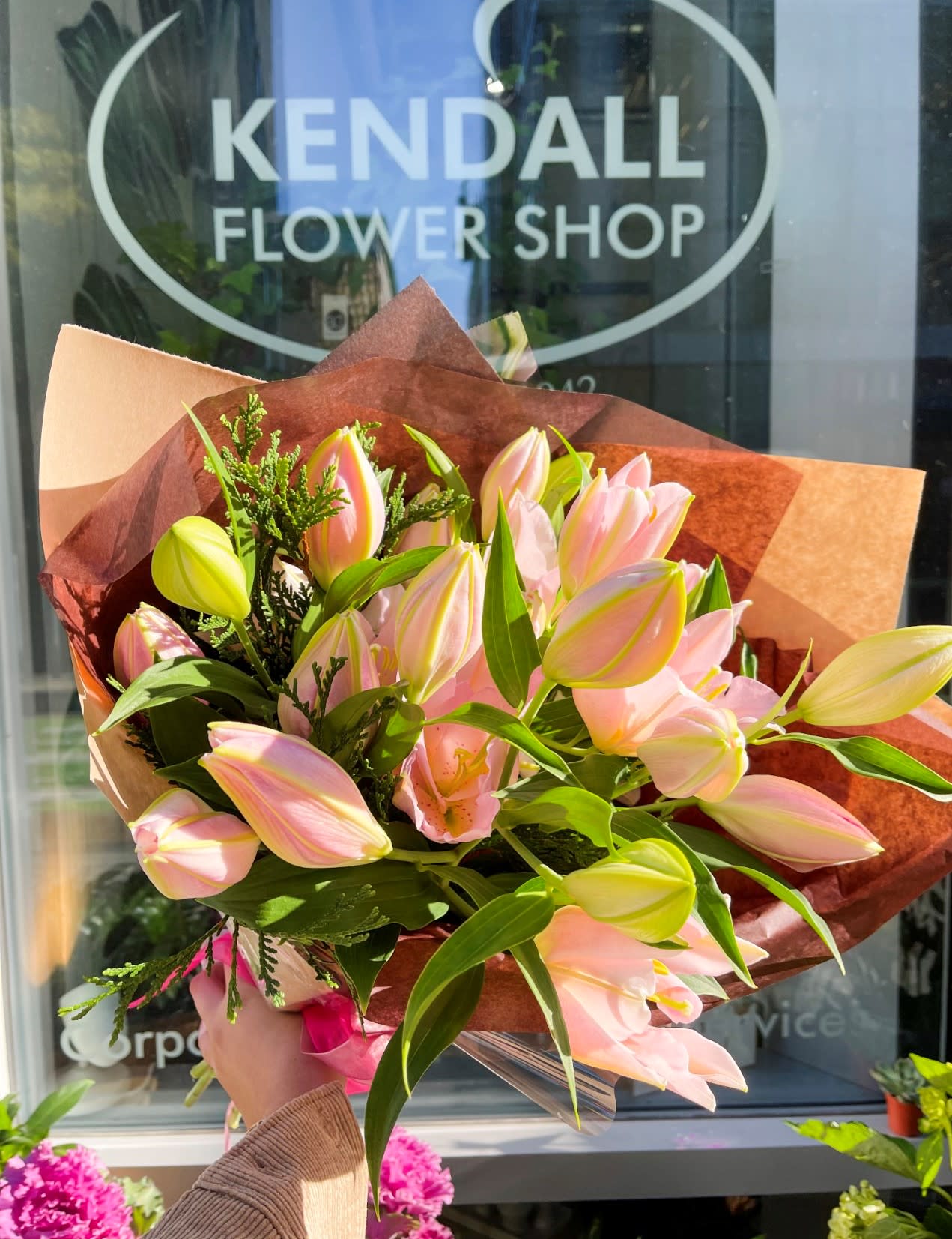 Bouquet of pink and yellow tulips wrapped in brown paper