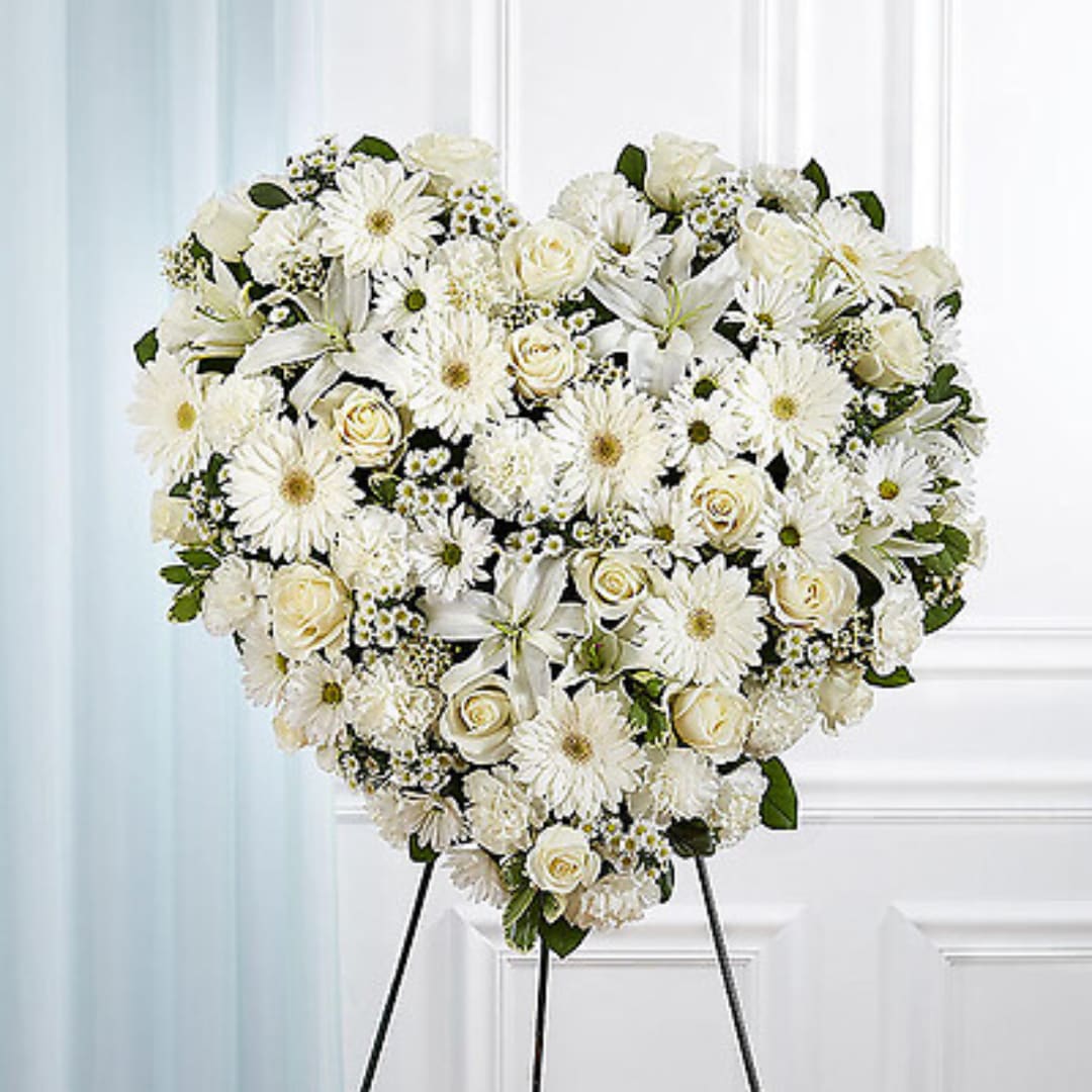 Heart-shaped white floral standing spray on an easel