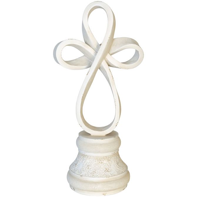 White sculpted cross figurine with looping design on decorative pedestal base