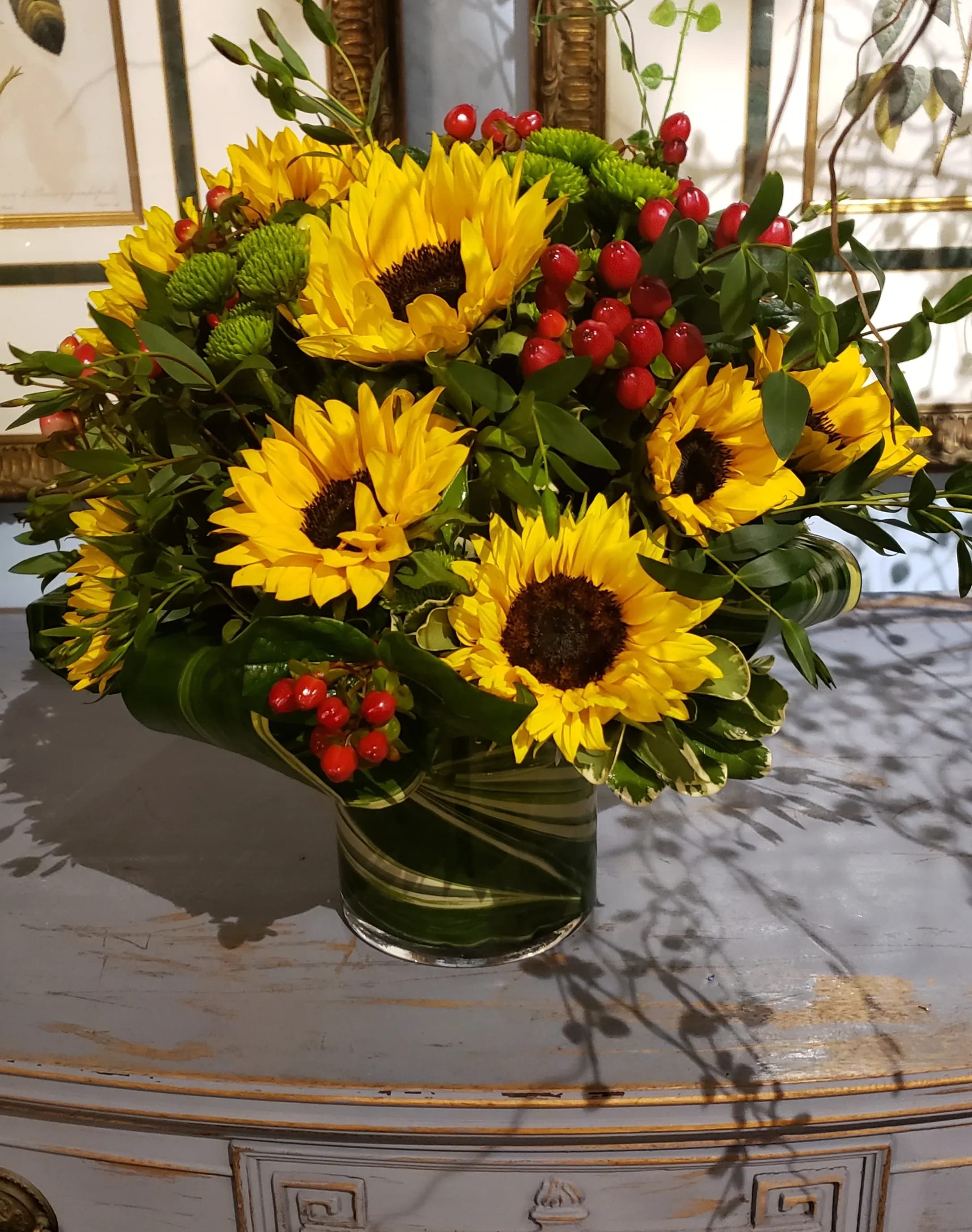 Bright and Shine Bouquet - An elegant gathering vase filled with 20 seasonal bright sunflowers and &amp; red hypericum berries create a beautiful and bold summer image.  At Belden's Florist we stand behind the quality of our products. We guarantee that our flowers will remain fresh and beautiful for 3-5 days after delivery. As cut flowers, they may naturally start to wilt beyond this timeframe. However, we ensure that you receive the freshest blooms possible, carefully selected and expertly arranged to bring joy and elegance to your space. To help your flowers stay fresher longer, we recommend adding fresh water to the vase regularly. Just like you, flowers need hydration to thrive, and refreshing the water allows them to drink up and continue to dazzle you with their beauty.