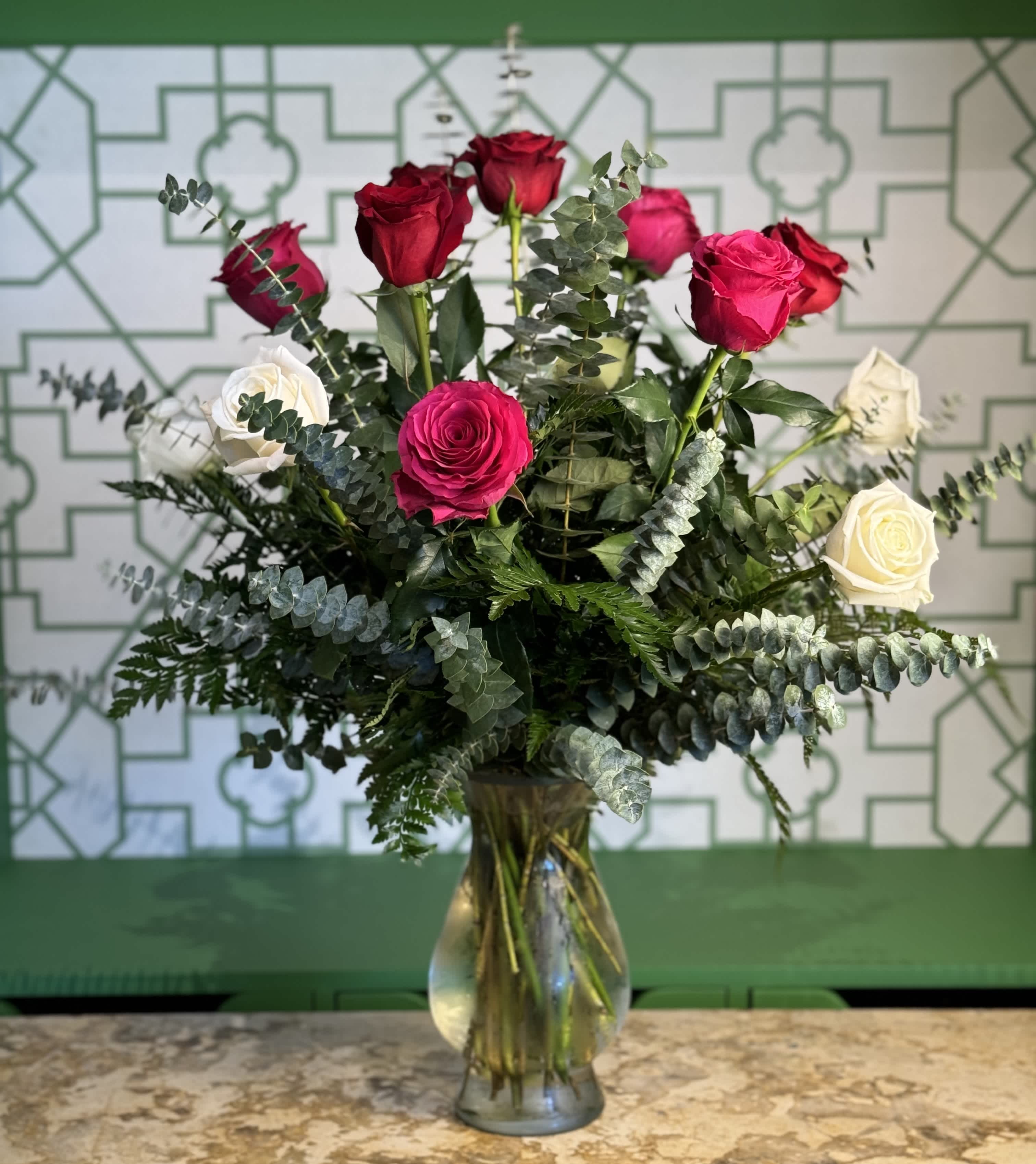 Bouquet of red, pink, and white roses in a glass vase