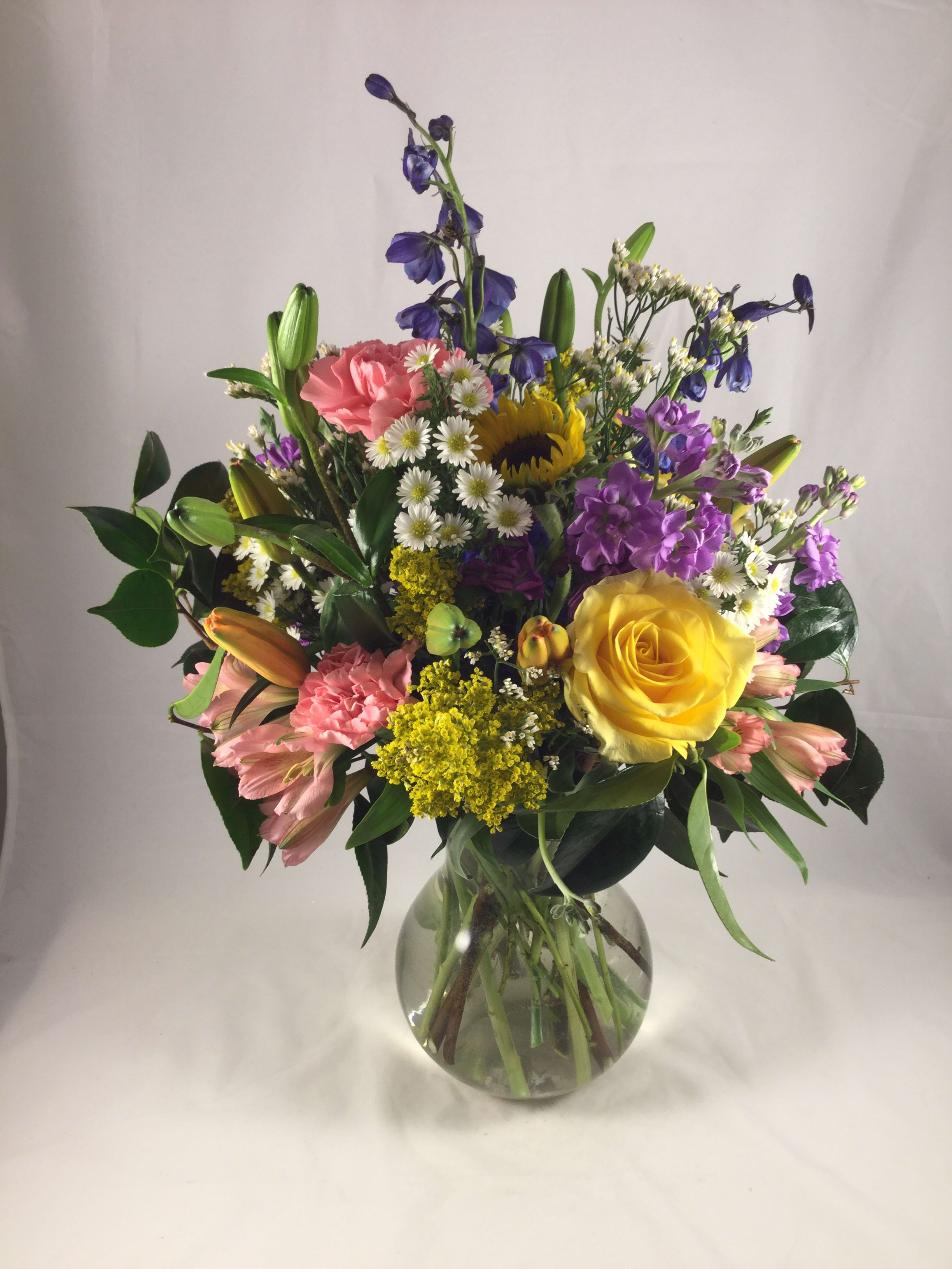 Mixed bouquet of colorful flowers in a clear glass vase