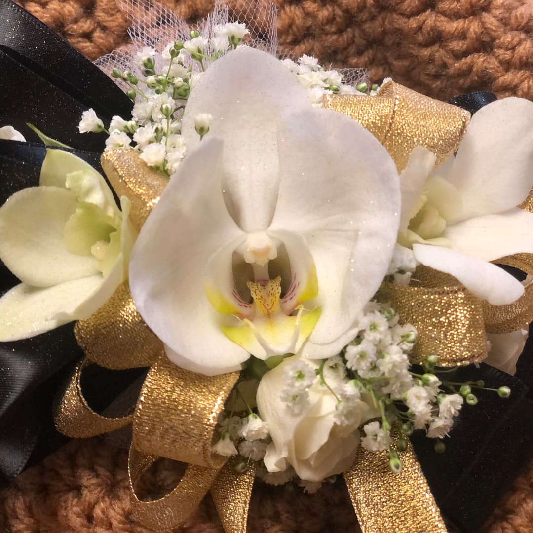 White orchid corsage with gold ribbon and small white filler flowers