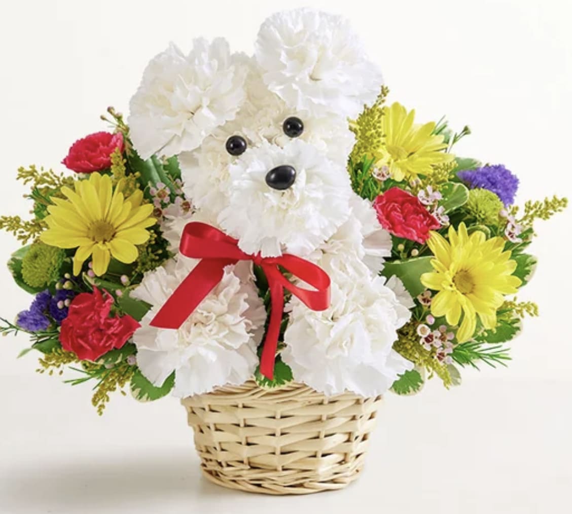 White teddy bear made of flowers in a wicker basket with a red bow