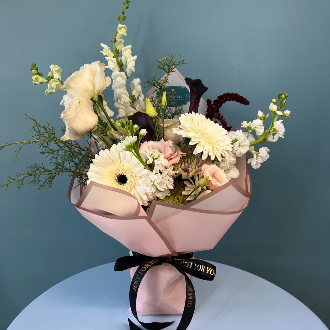 Bouquet of white and blush flowers wrapped in pink paper