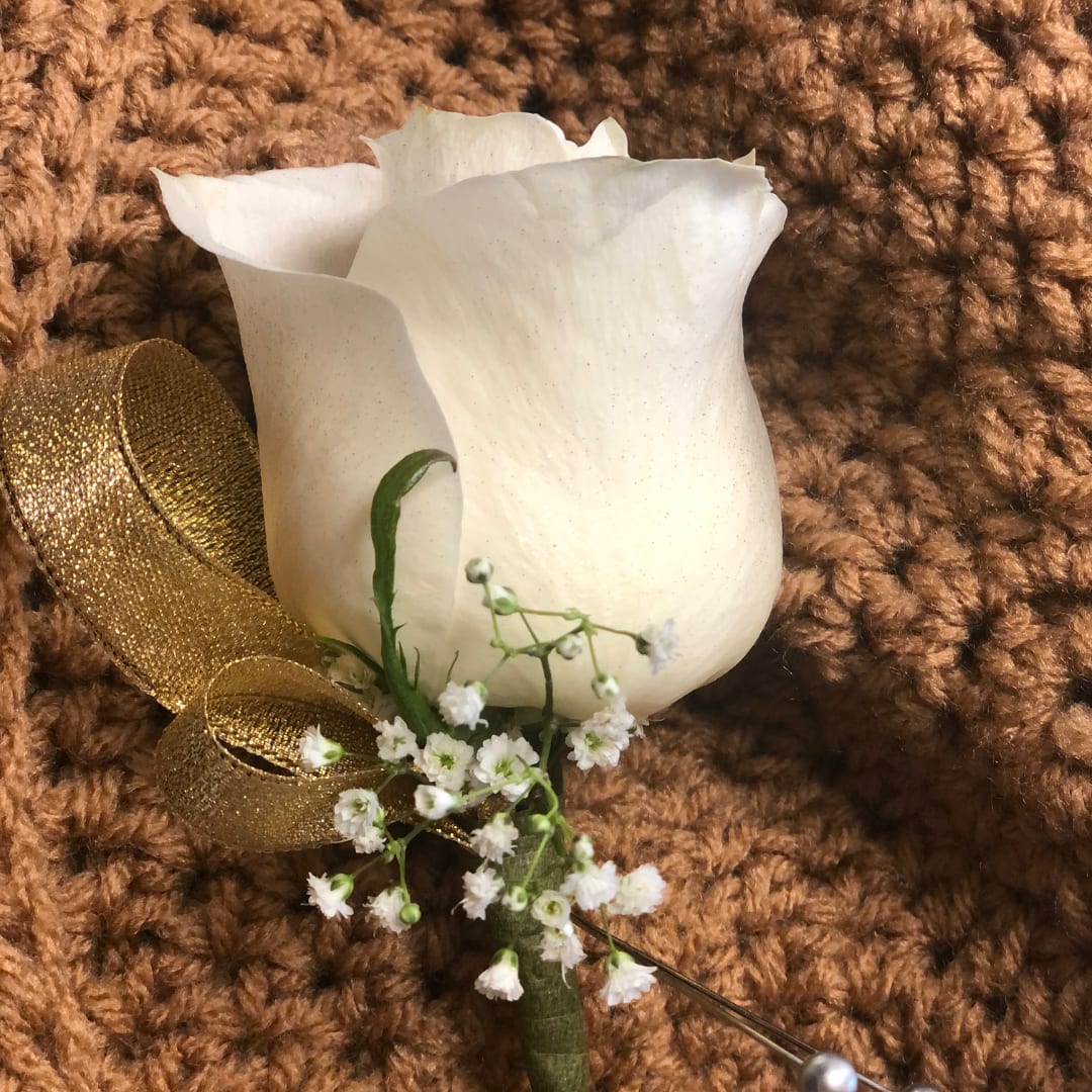 White rose boutonniere with baby's breath and gold ribbon