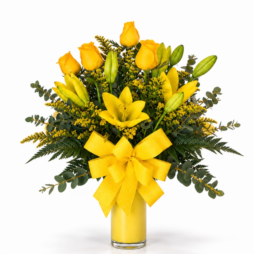 Yellow roses and lilies in a glass vase with a yellow bow