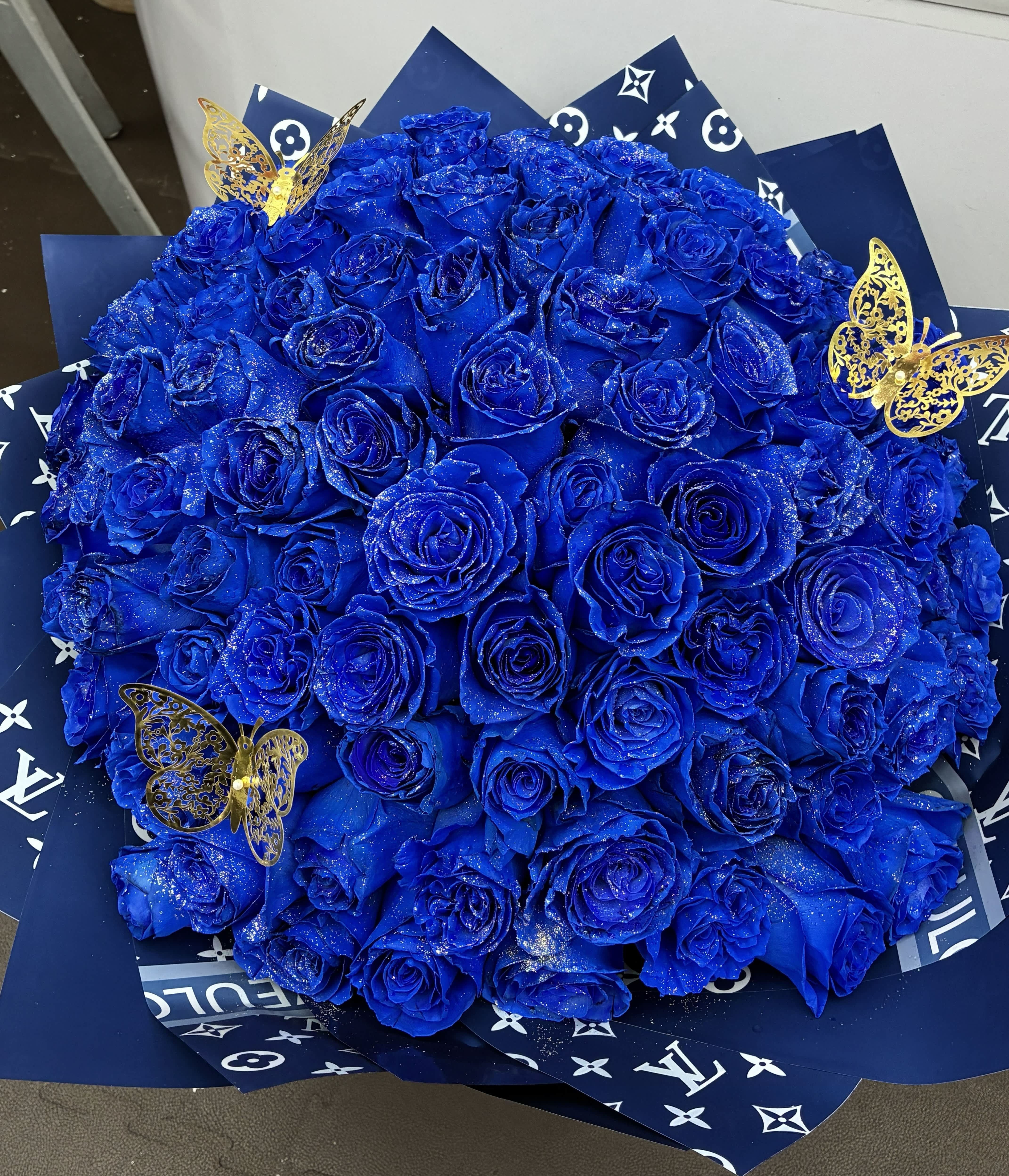100 Blue Roses Arrangement -  100 Blue Roses – A Symbol of Love and Mystery   A stunning bouquet of 100 blue roses, representing deep love, loyalty, trust, and the beauty of the impossible. Each rose carries a special meaning, creating a breathtaking arrangement that expresses a love as rare and extraordinary as the color blue itself. Perfect for anniversaries, birthdays, romantic surprises, or making someone feel truly special. 