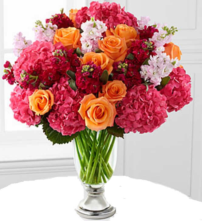 Bouquet of orange roses and pink hydrangeas in a clear glass vase