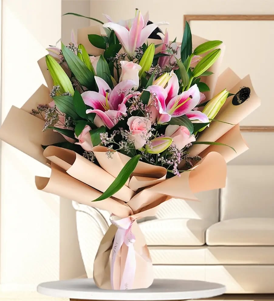 Bouquet of pink lilies and roses wrapped in beige paper