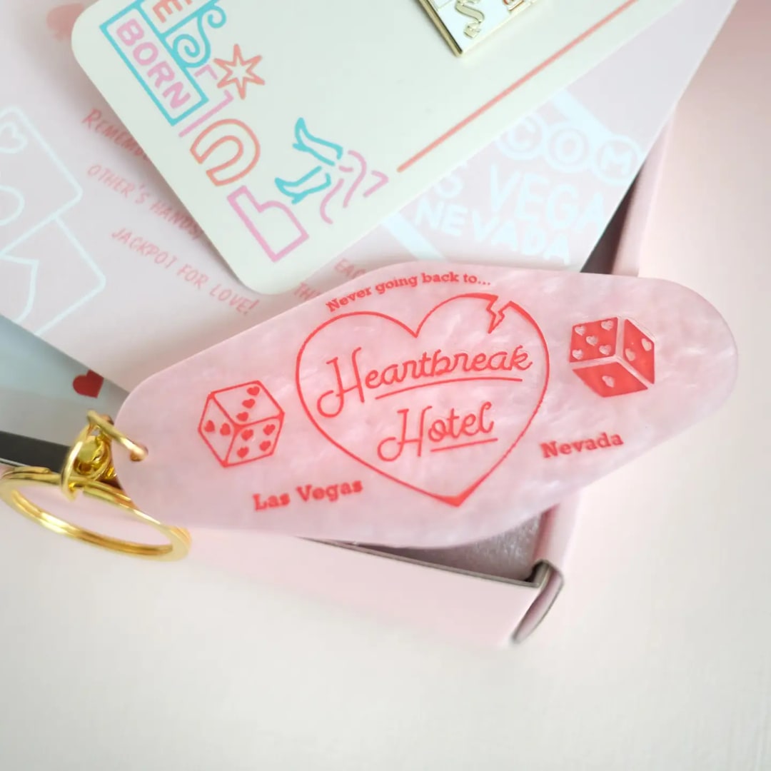 Pink keychain with a heart and "Heartbreak Hotel" text