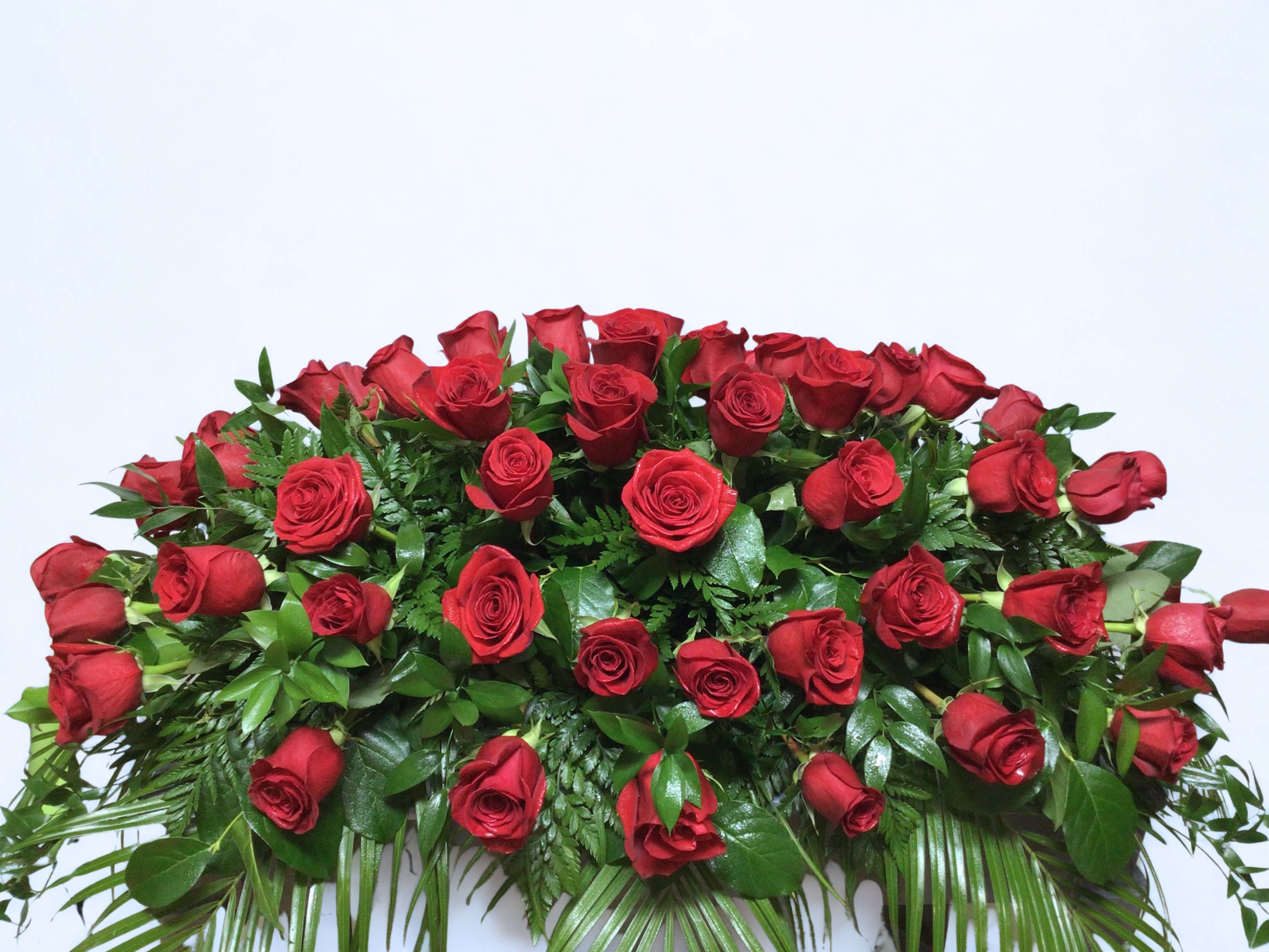 Large arrangement of red roses with dense greenery