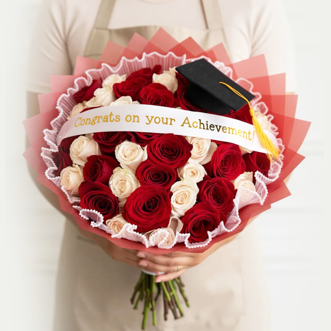 Bouquet of red and white roses with a graduation cap and ribbon