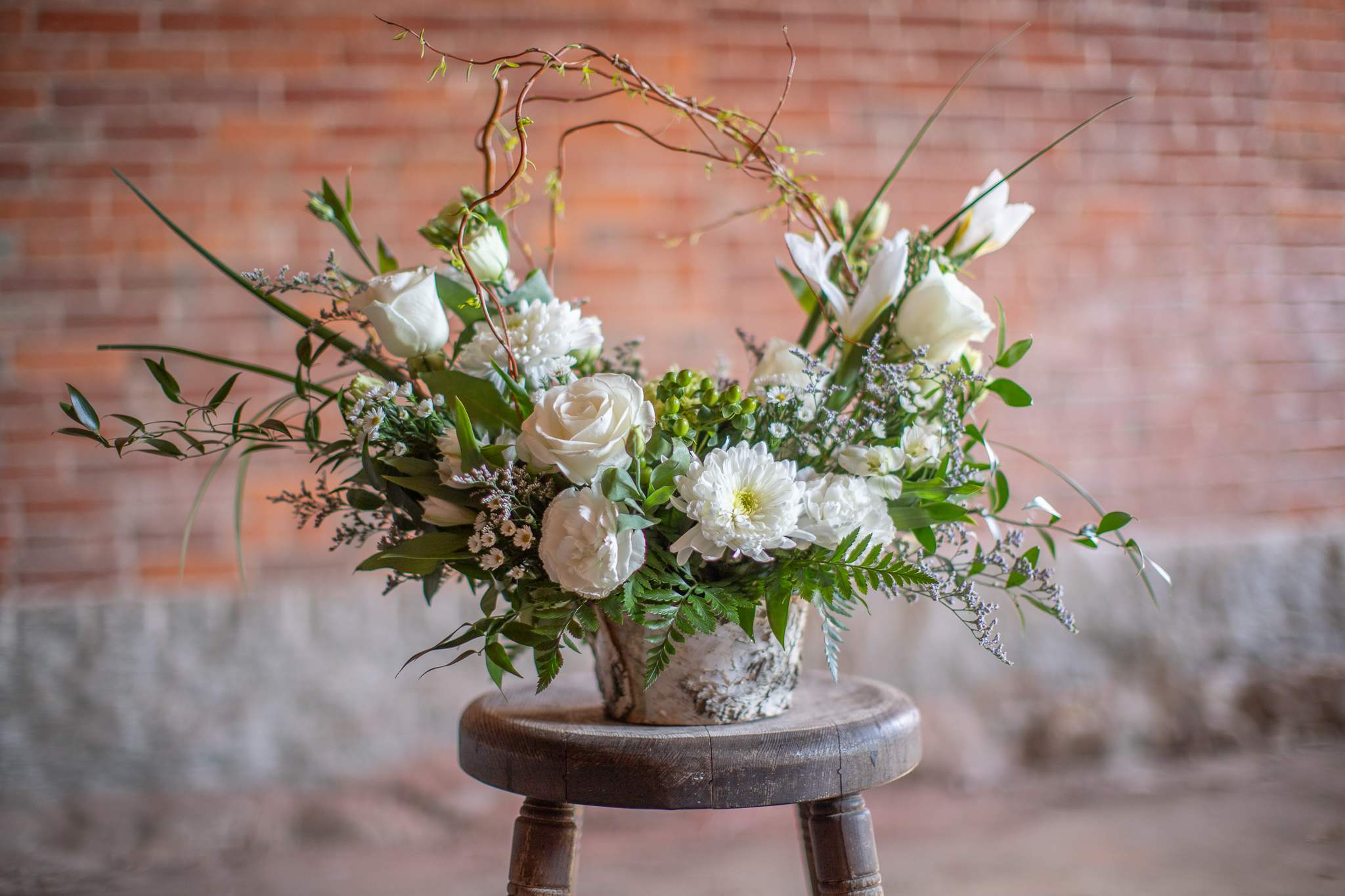 White floral arrangement in a rustic metal container