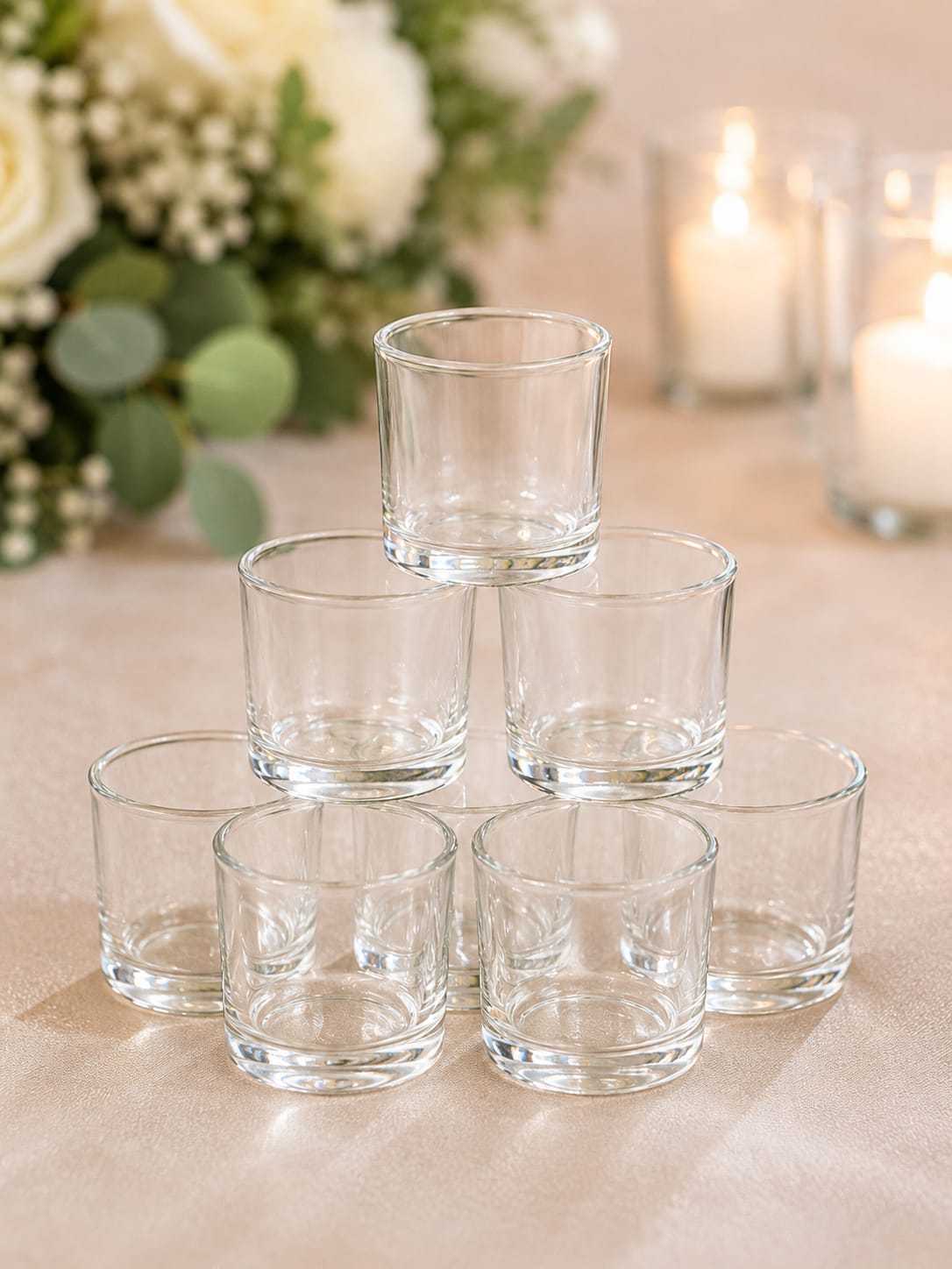 Natalie Votives - Natalie Votives  Sometimes it’s the smallest details that make the biggest impact. Natalie Votives create a warm, romantic glow that adds depth, elegance, and ambiance to your event design. Their classic clear-glass styling blends beautifully with virtually any wedding theme, from rustic and garden-inspired celebrations to timeless ballroom receptions.  Available in a set of eight, Natalie Votives are perfect for mixing with larger candle holders, hurricanes, lanterns, compotes, and floral centerpieces to create a layered, professionally styled tablescape. Use them to add sparkle to sweetheart tables, guest tables, cocktail tables, gift displays, and welcome areas while creating the inviting atmosphere guests remember long after the celebration ends.  The secret to a stunning reception isn’t simply more décor—it’s thoughtful details that work together. Natalie Votives provide the finishing touch that brings warmth, romance, and cohesion to your overall design.  Perfect For: Weddings, bridal showers, rehearsal dinners, engagement parties, anniversaries, and special events.