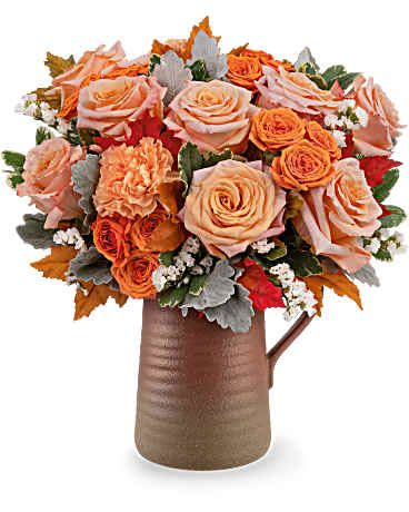 Peach and orange rose bouquet in a brown vase