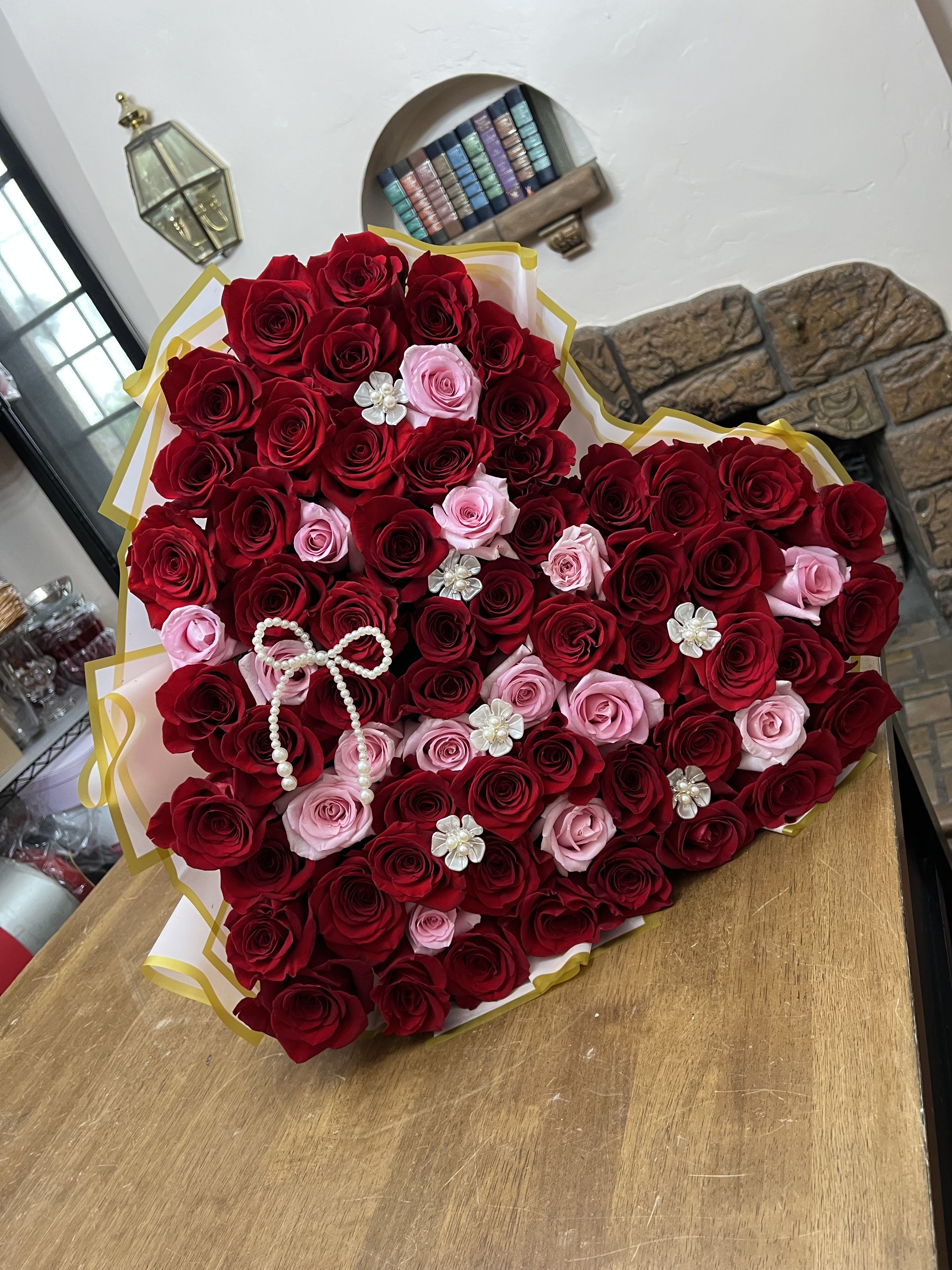 Heart Shape Wrapped bouquet - A heart-shaped wrapped bouquet made with roses in shades of red and pink. If you prefer a different rose color, please include your request in the special instructions.