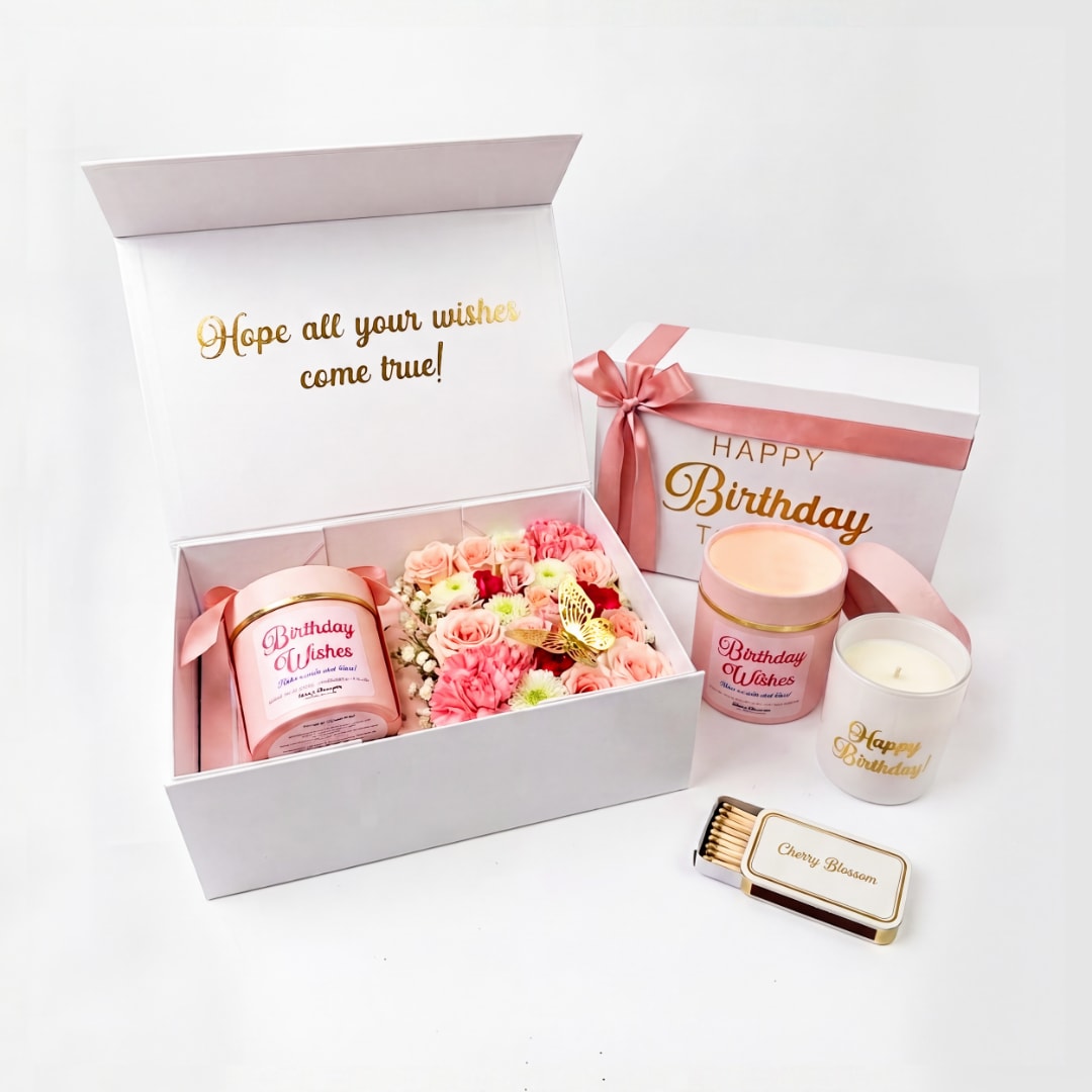 Birthday gift boxes with pink flowers, candles, and a matchbox