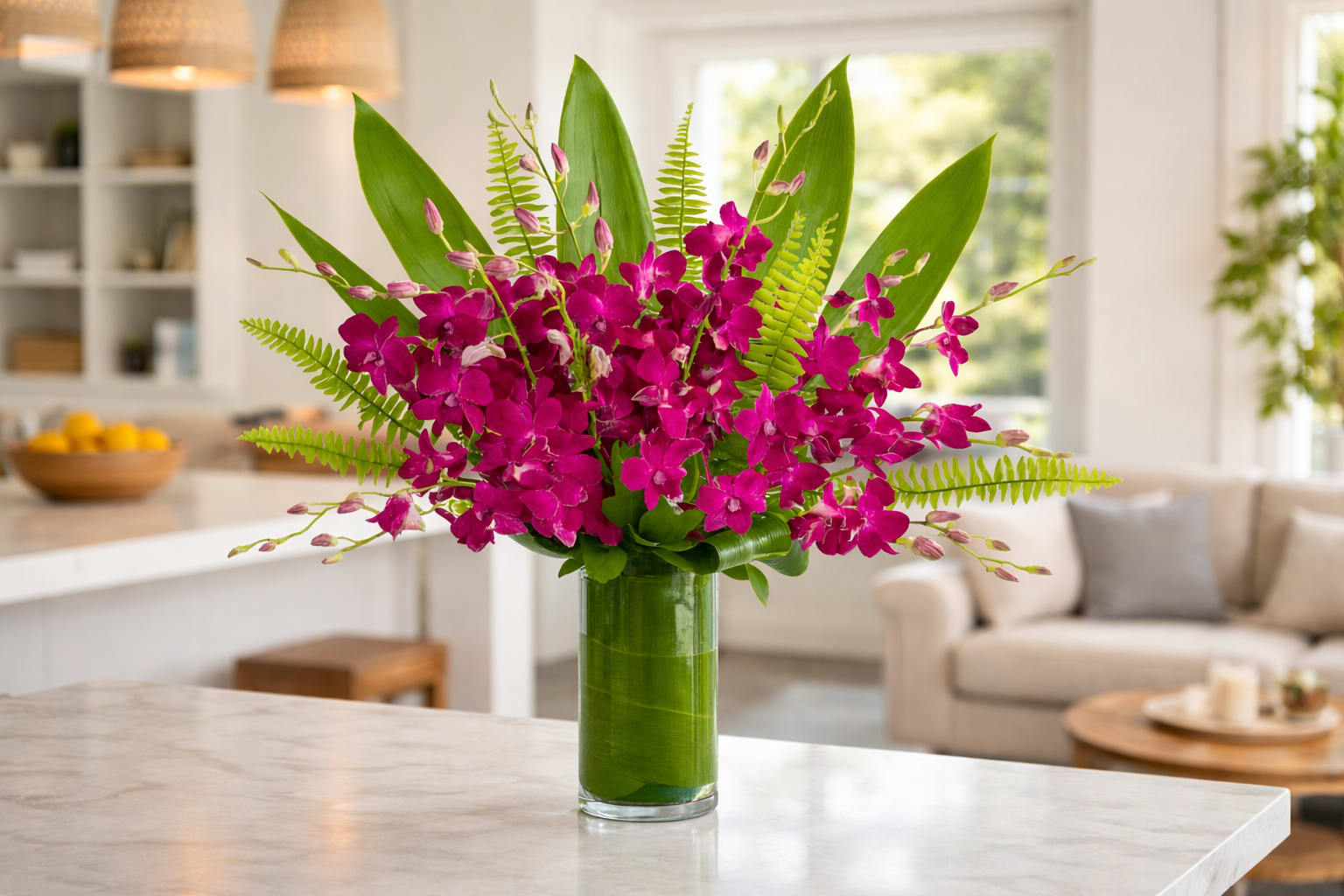 Magenta orchids arranged in a tall glass vase with fern accents