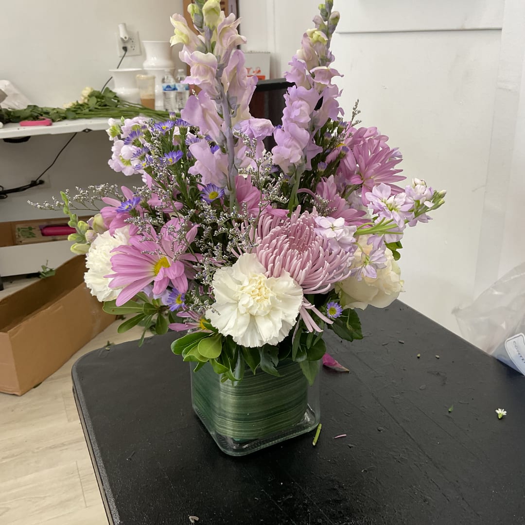 Pink and white mixed bouquet in a square glass vase