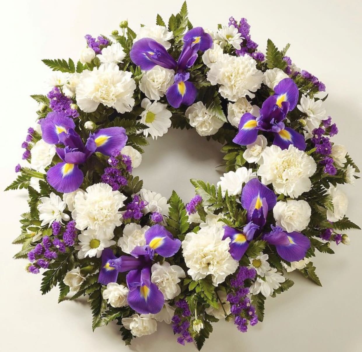 Circular floral wreath with white blooms and purple irises