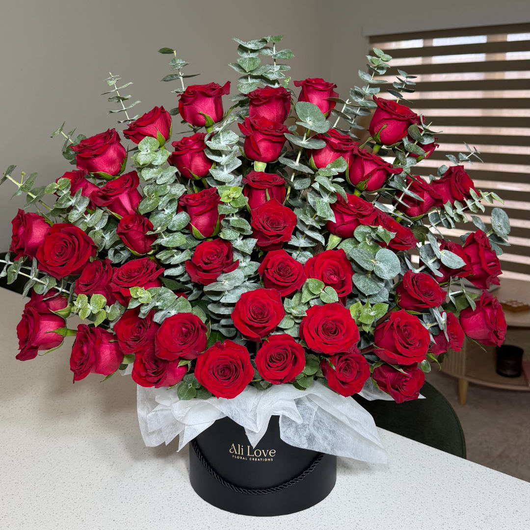 Large bouquet of red roses with eucalyptus in a black hat box