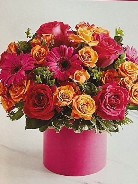 A Happy Gerber Delight - Hot pink gerberas, roses, orange spray roses, green buttons and pink wax flowers. Arranged in hot pink ceramic vase. For Valentines day comes with bow and pick