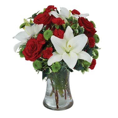 HOLIDAY CELEBRATION BOUQUET - Product ID: BF202-11KS  You can almost hear the sleigh bells ringing as this astonishing bouquet evokes the wonders of the holidays. White Asiatic lilies, red roses, red mini carnations and green button poms are set in a clear gathering vase. Small Measures 14?H by 11?L. Medium Measures 15?H by 12?L. Large Measures 16?H by 13?L.