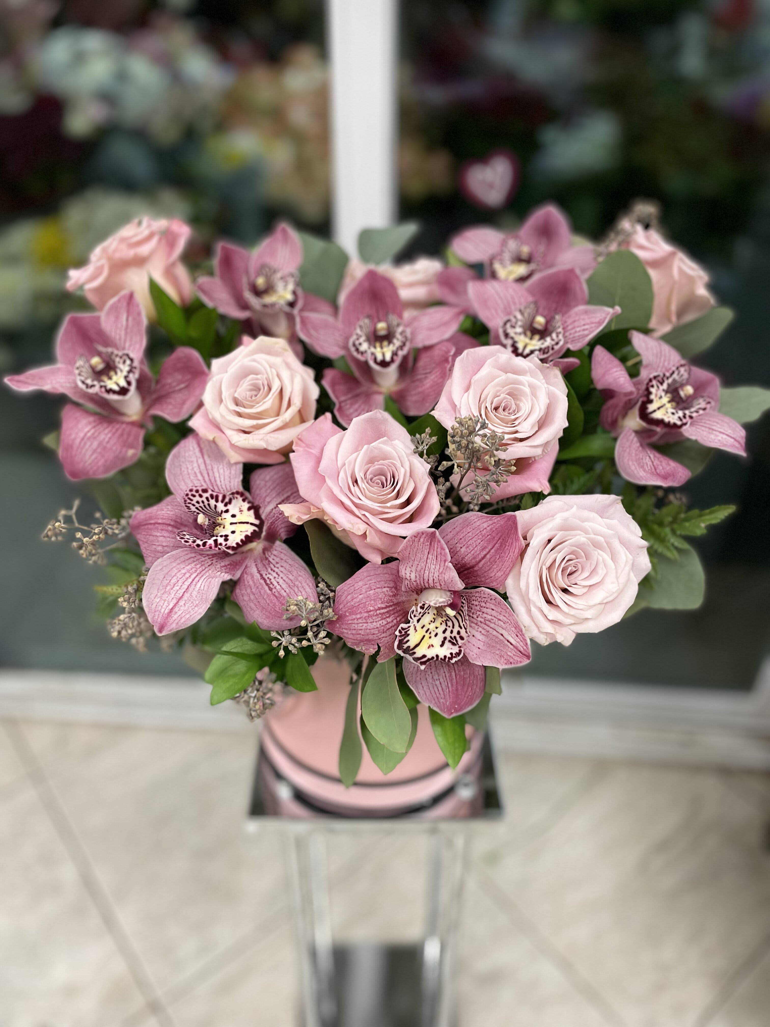 Pink roses and orchids arranged in a vase