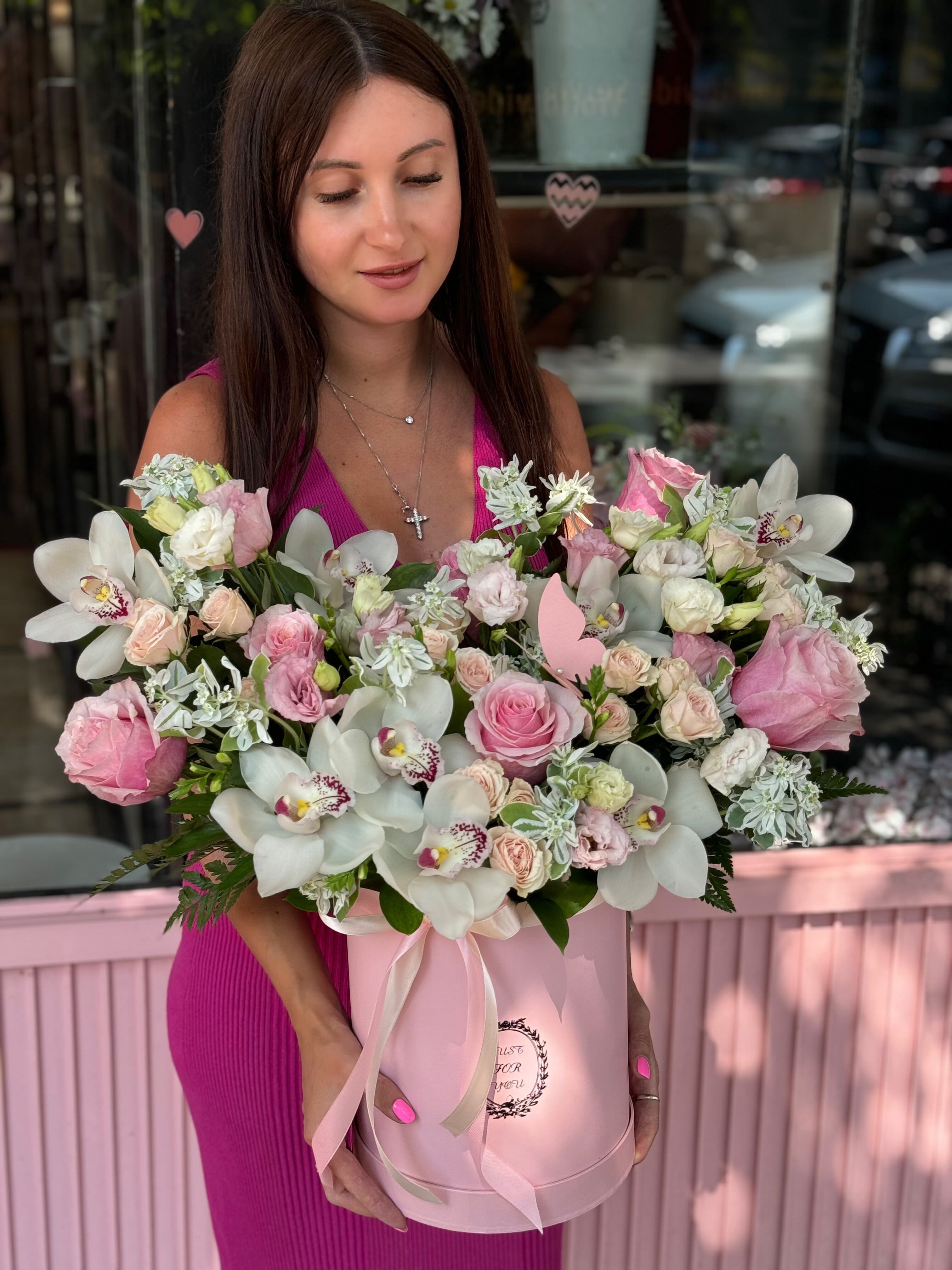 Woman holding a pink box of pink and white flowers