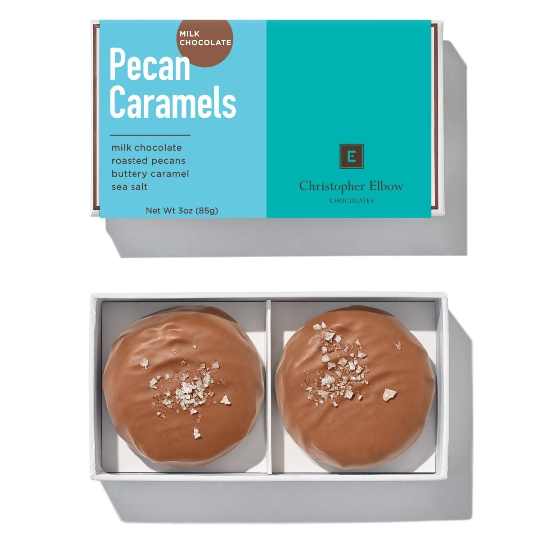 Box of milk chocolate pecan caramels with two round candies inside