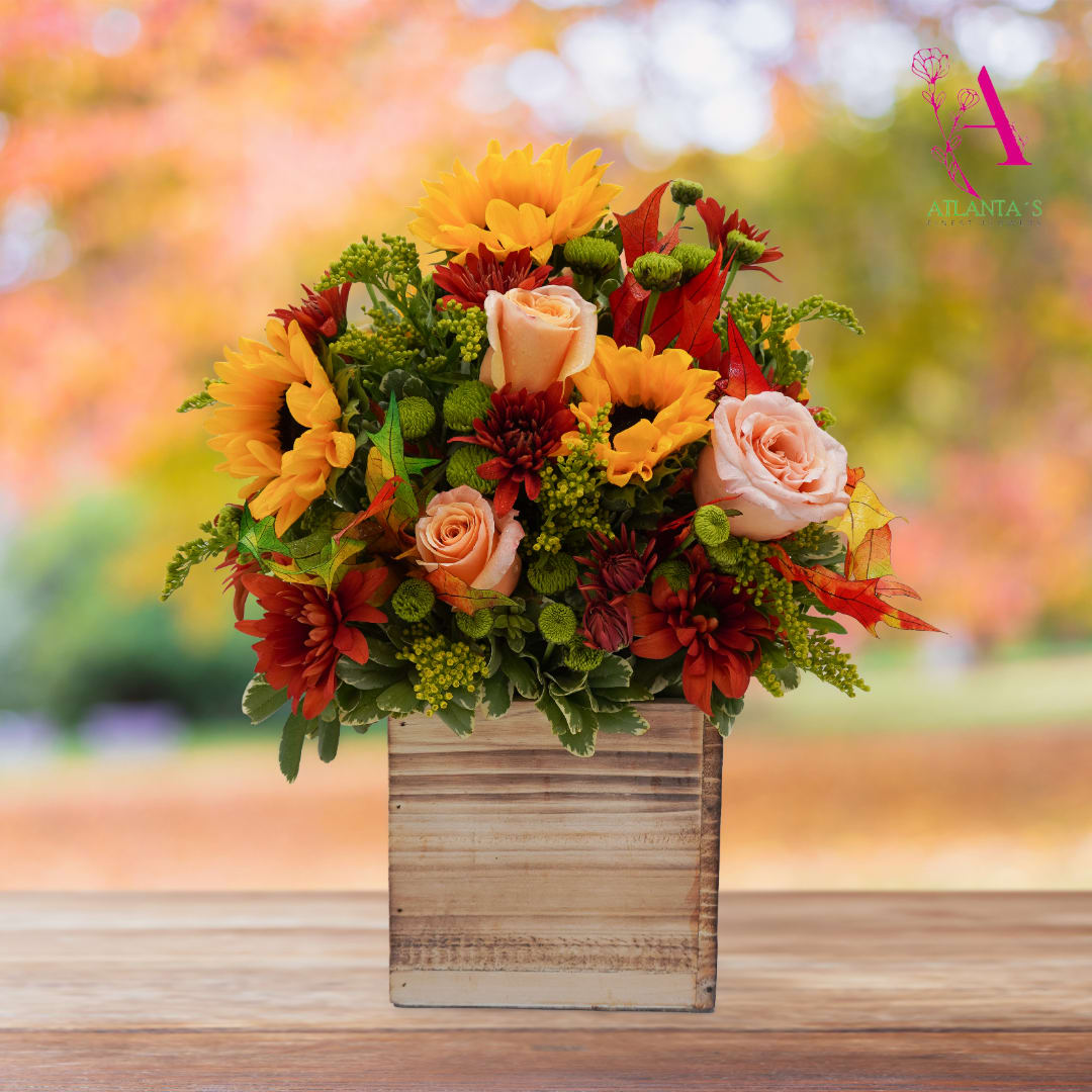 Autumn floral arrangement with sunflowers, roses, and red mums in a wooden box