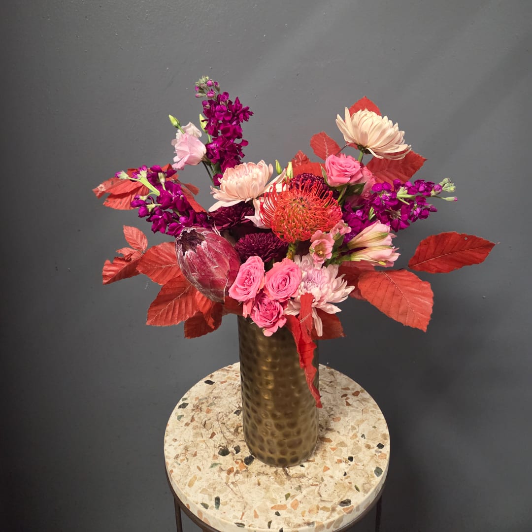 Pink and purple mixed bouquet in a tall gold vase