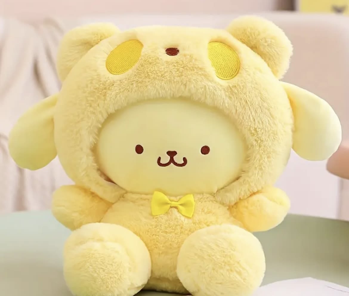 Yellow plush bear wearing a hood and bow tie
