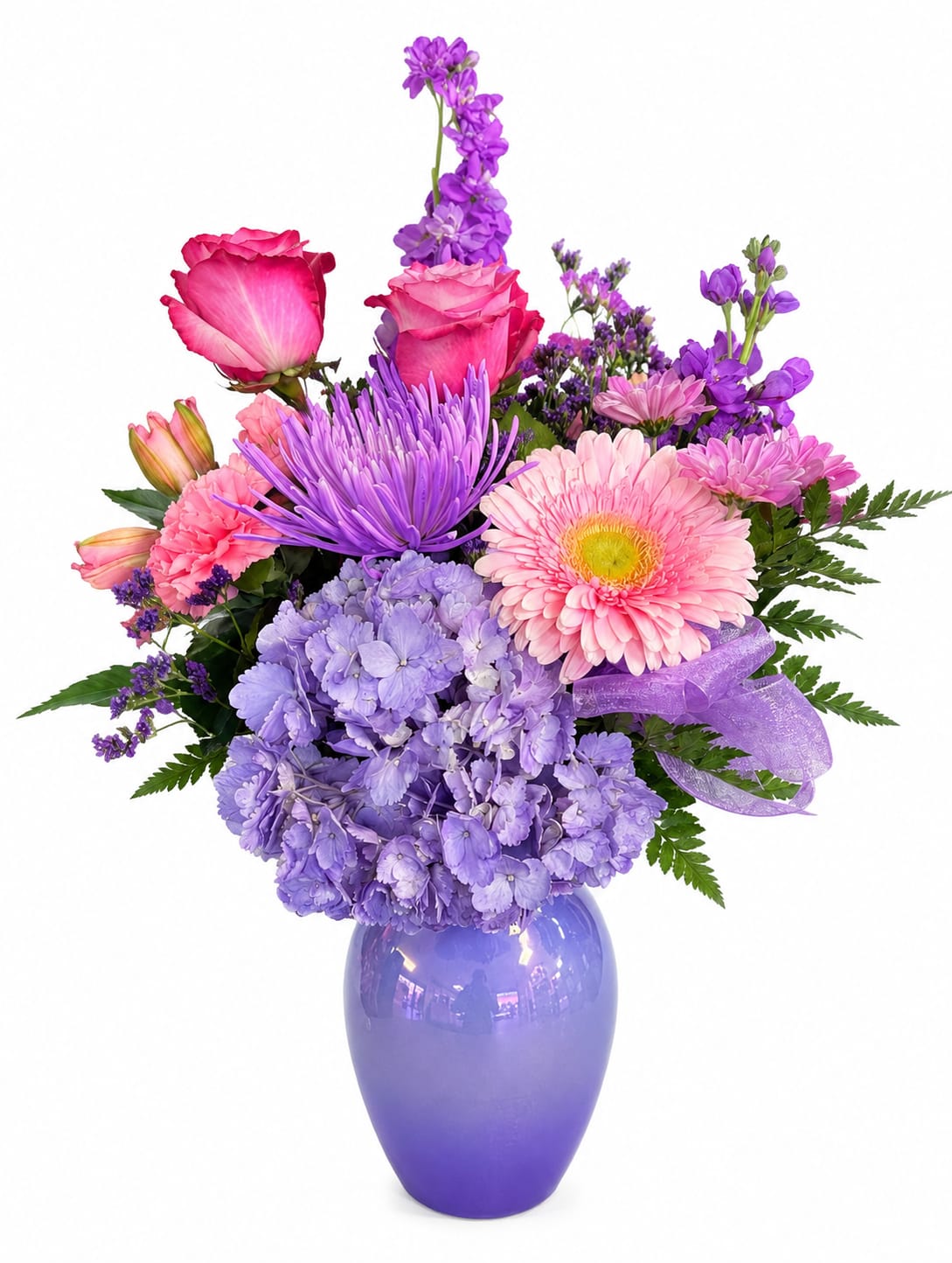 Purple and pink mixed flower arrangement in a purple vase