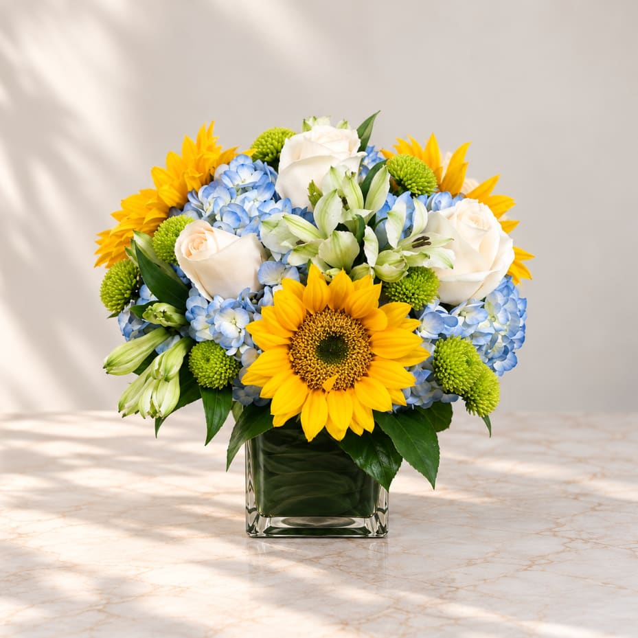 Sunflower and rose bouquet in a square glass vase