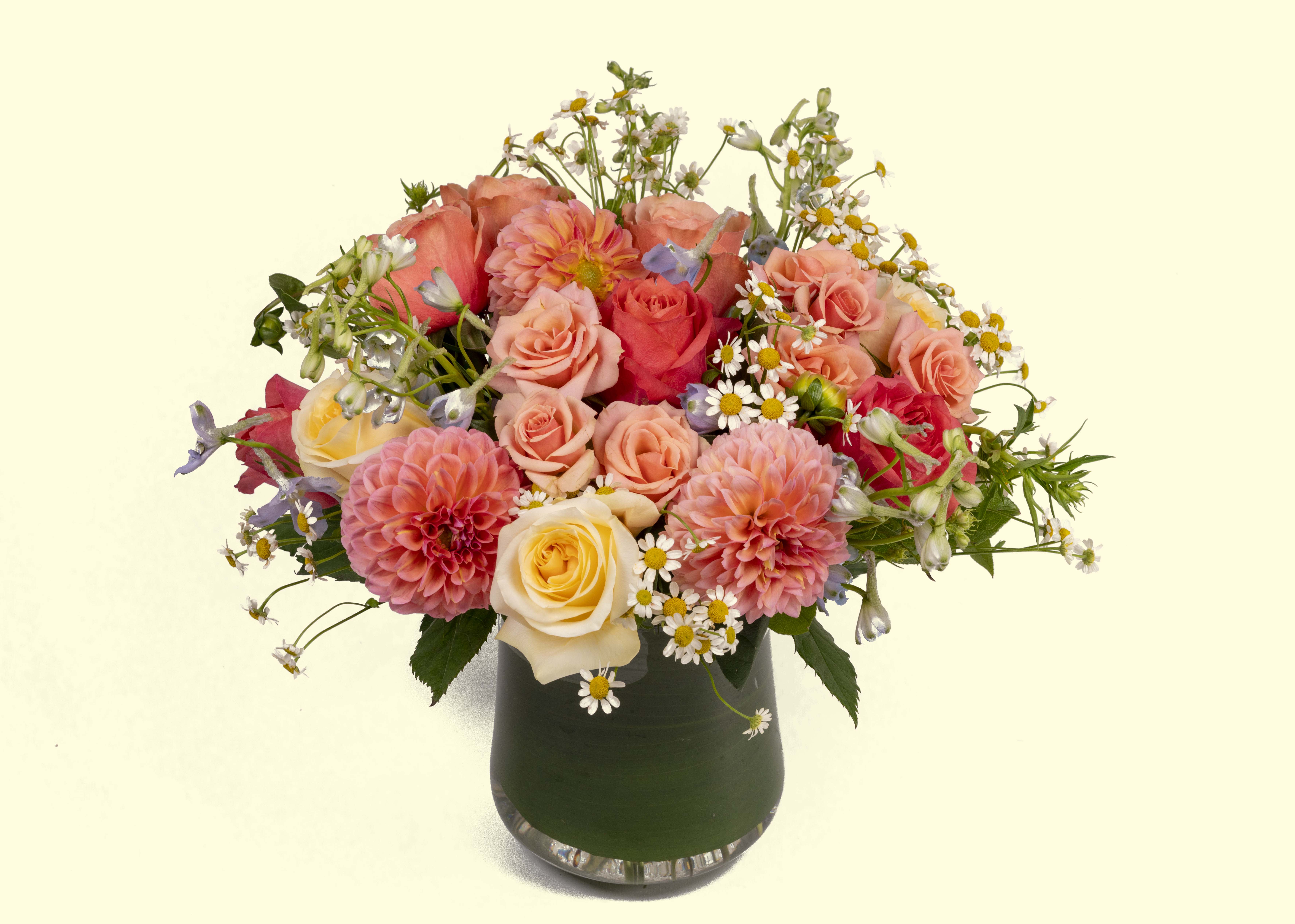 Enchanted Garden  - Roses, dahlias, spray roses, blue delphinium and more designed in a glass vase.