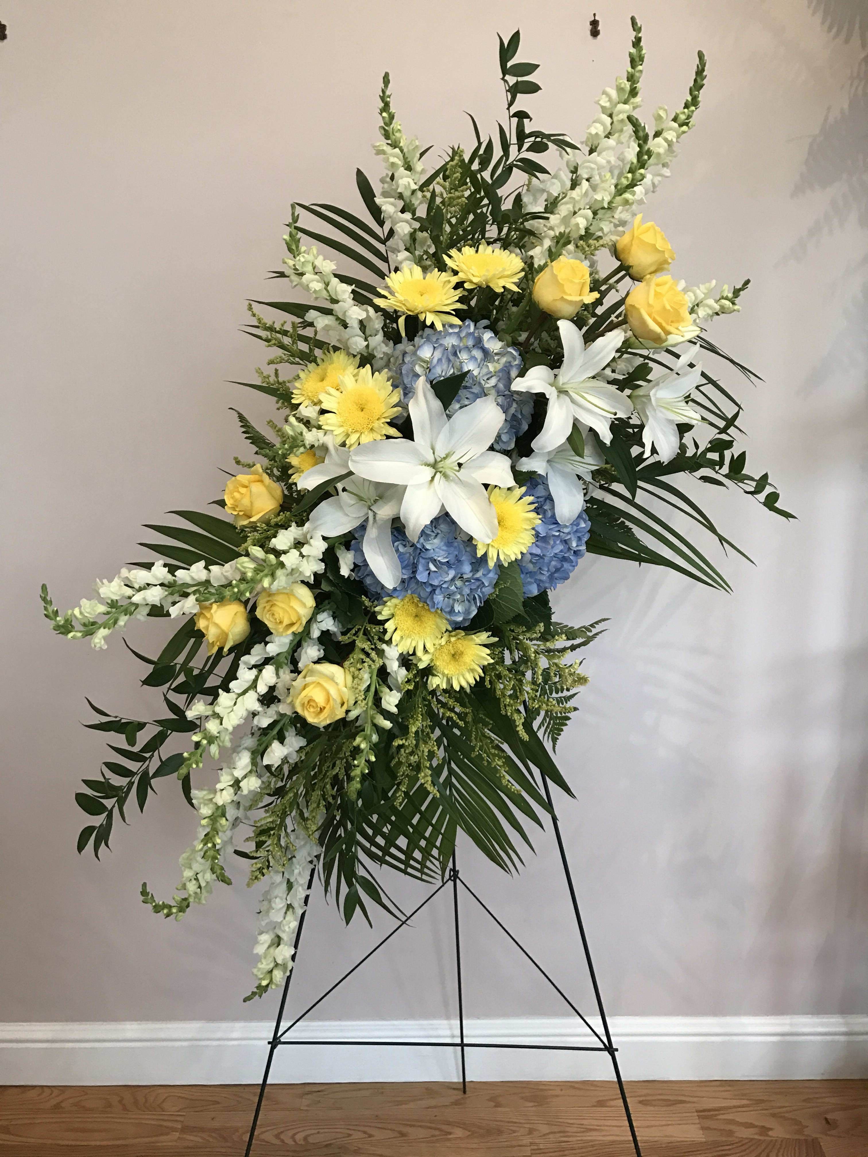 Spray of Light   - Blue hydrangea, yellow rose, white lily and more designed for a funeral service.