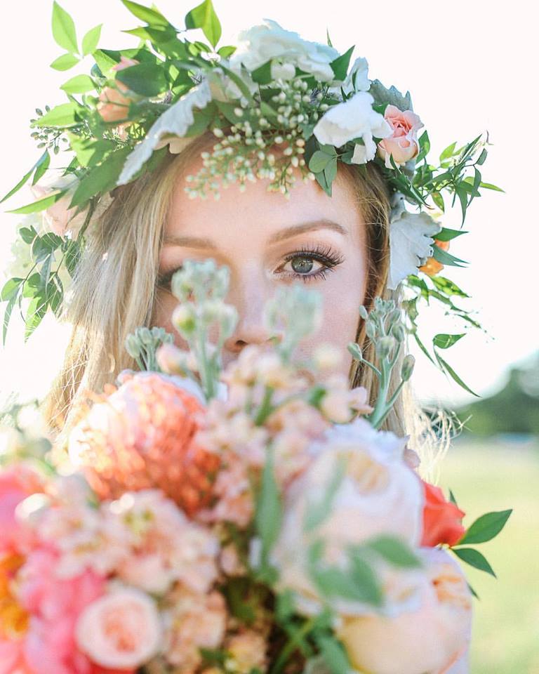 Woman wearing a floral crown and holding a pastel bouquet