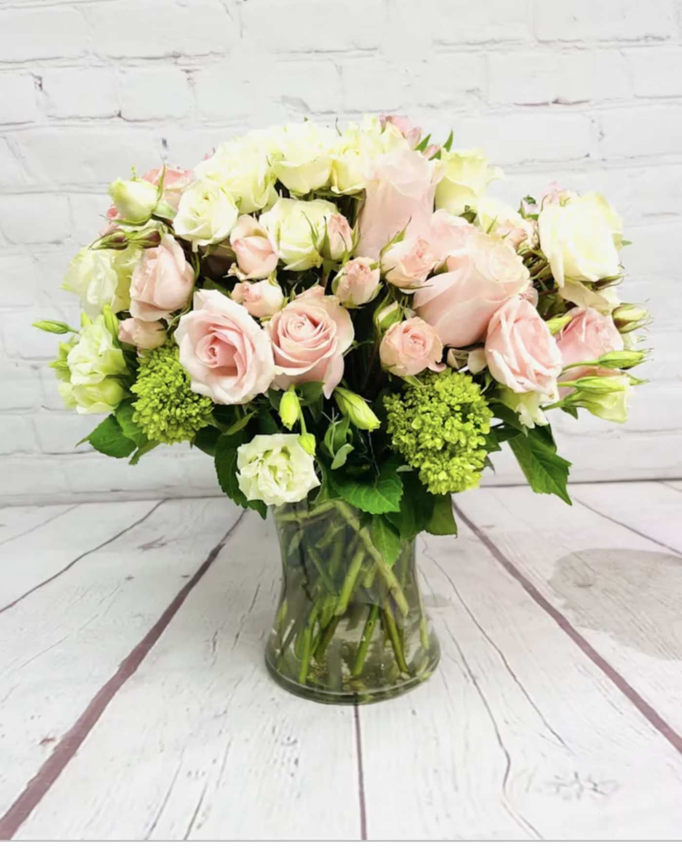 Pink and white roses arranged in a glass vase