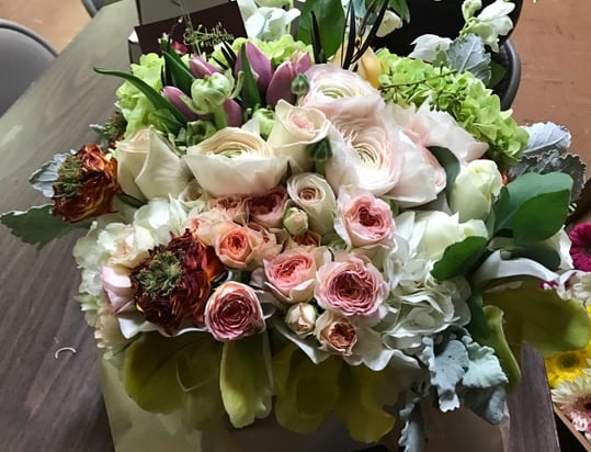 Mixed bouquet of pale pink and white flowers in a wrapped arrangement