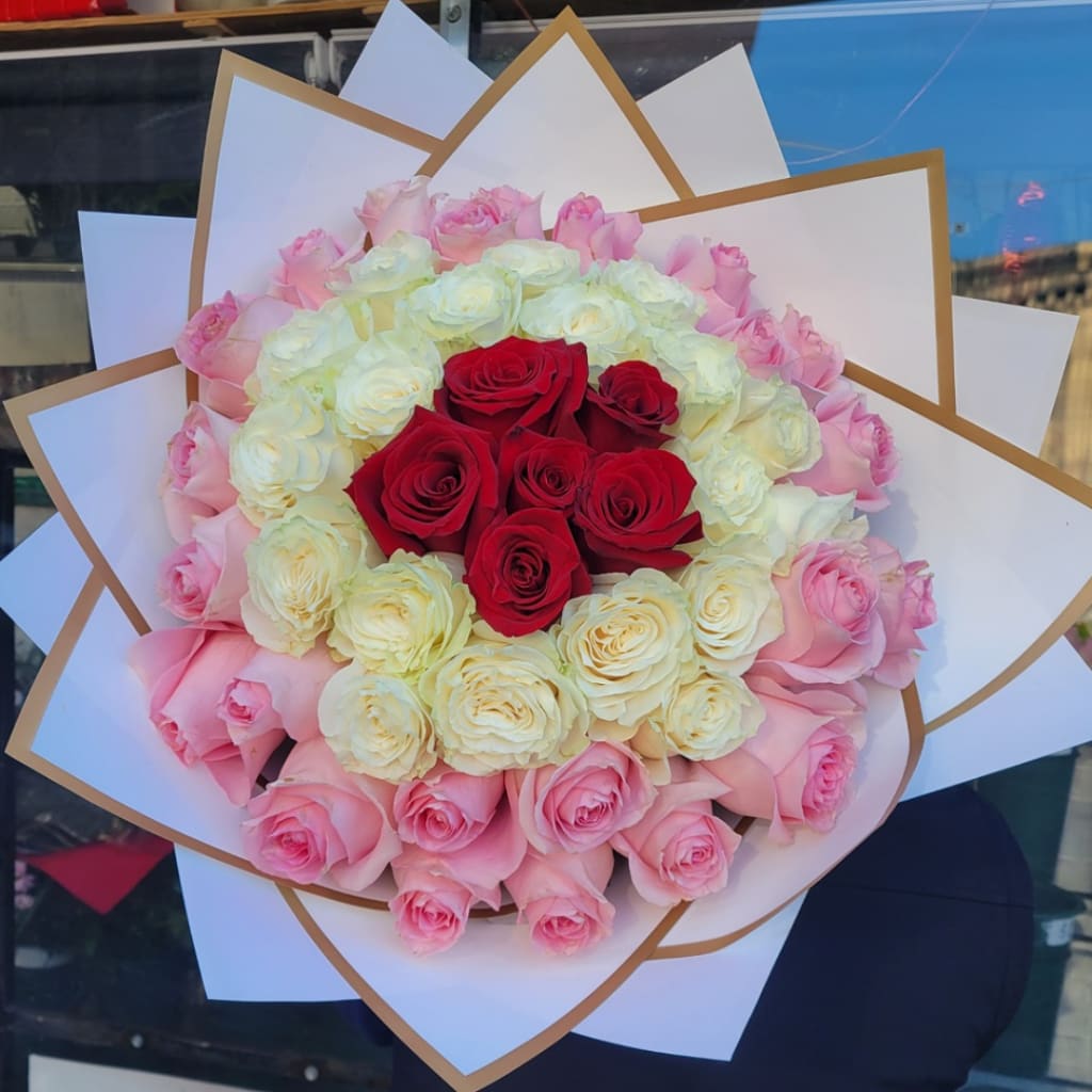 Bouquet of red, white, and pink roses wrapped in white paper