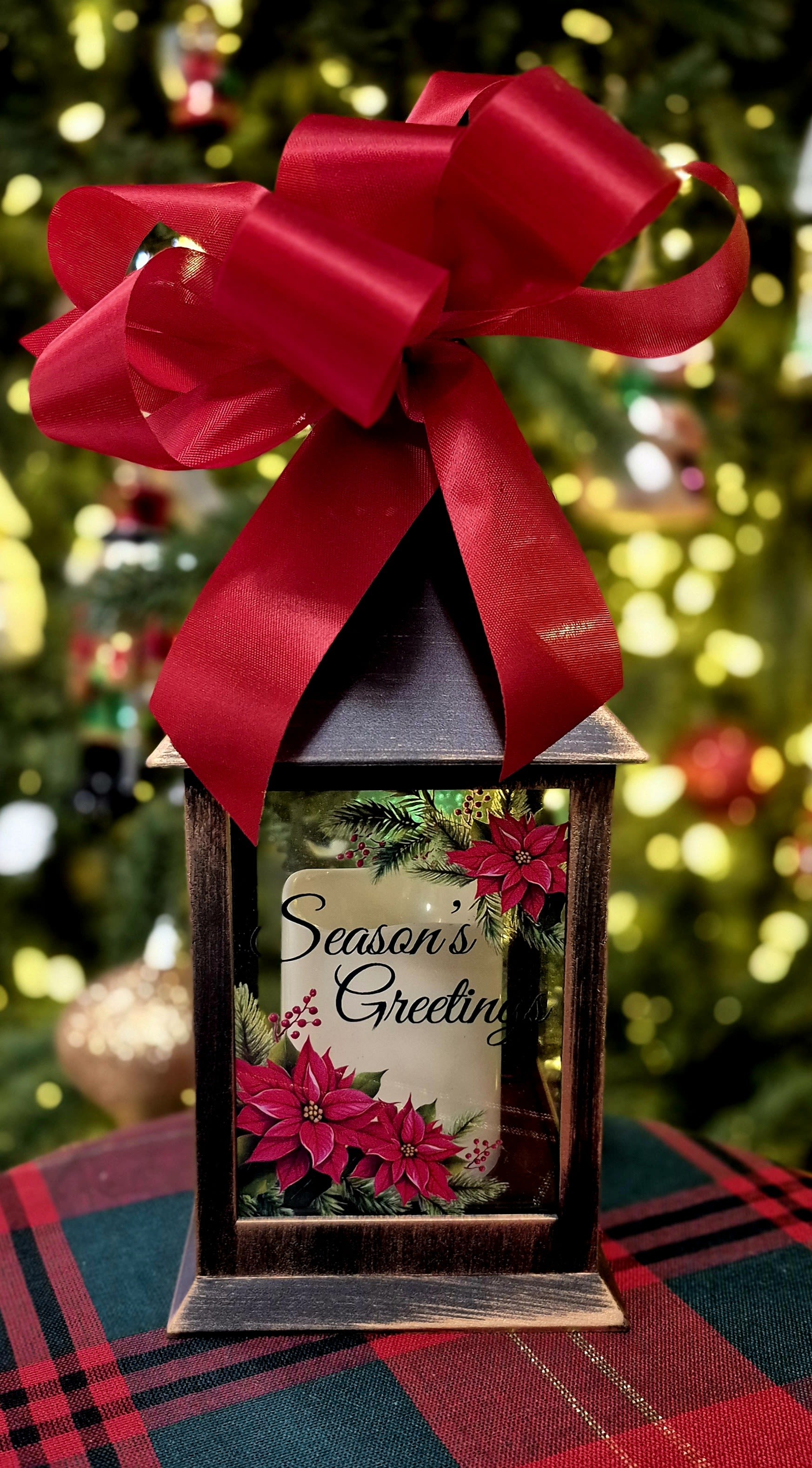 Decorative lantern with a red bow and a "Season's Greetings" holiday insert