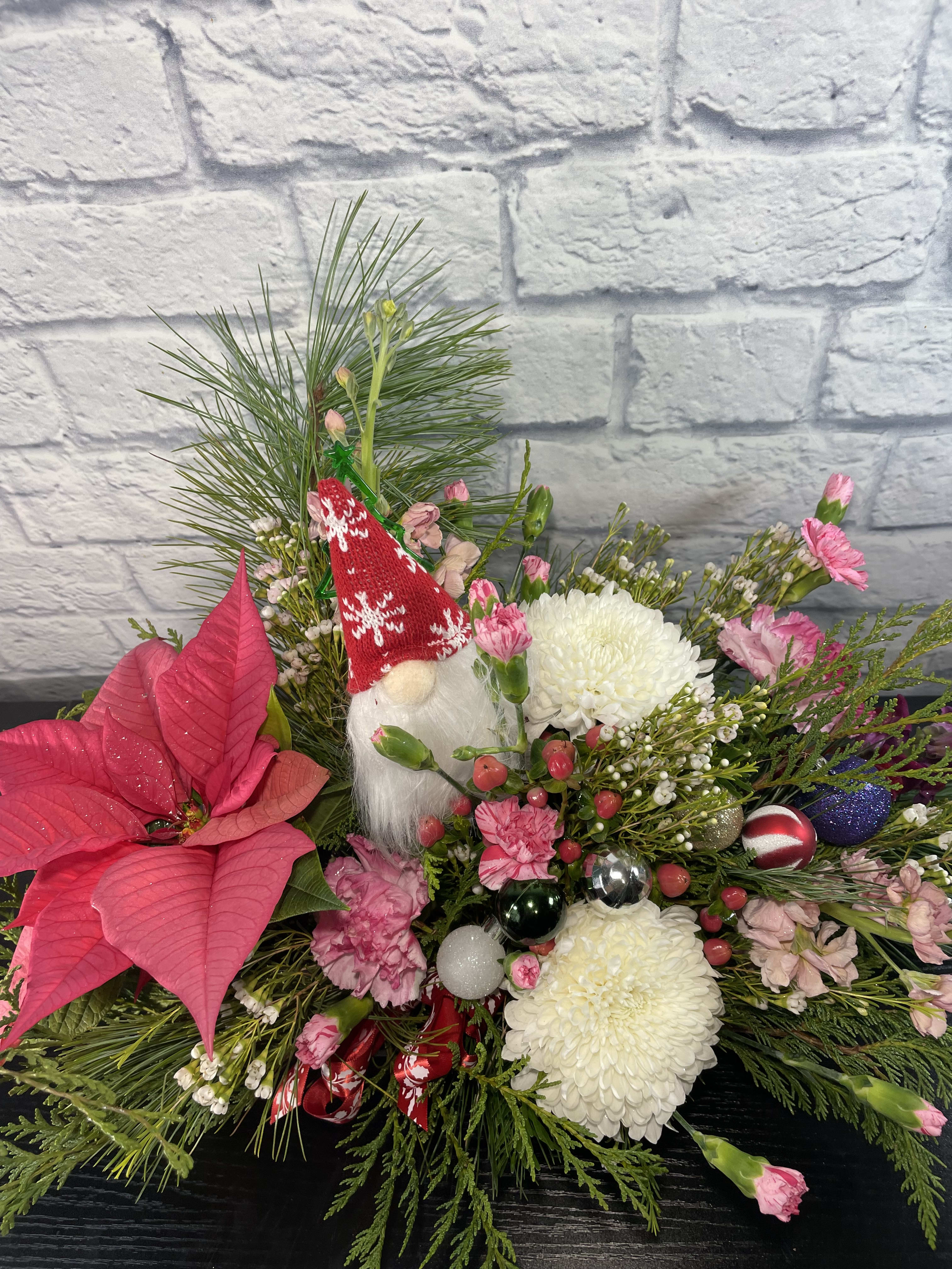 Mini Poinsettia Centerpiece - What a wonderful arrangement to send that'll last for a long time.  We place a mini poinsettia with fresh Christmas greenery, fresh flowers, small ornaments, and more to enjoy throughout the Christmas Season.  A sure pleaser for anyone's table.  A popular holiday arrangement too.