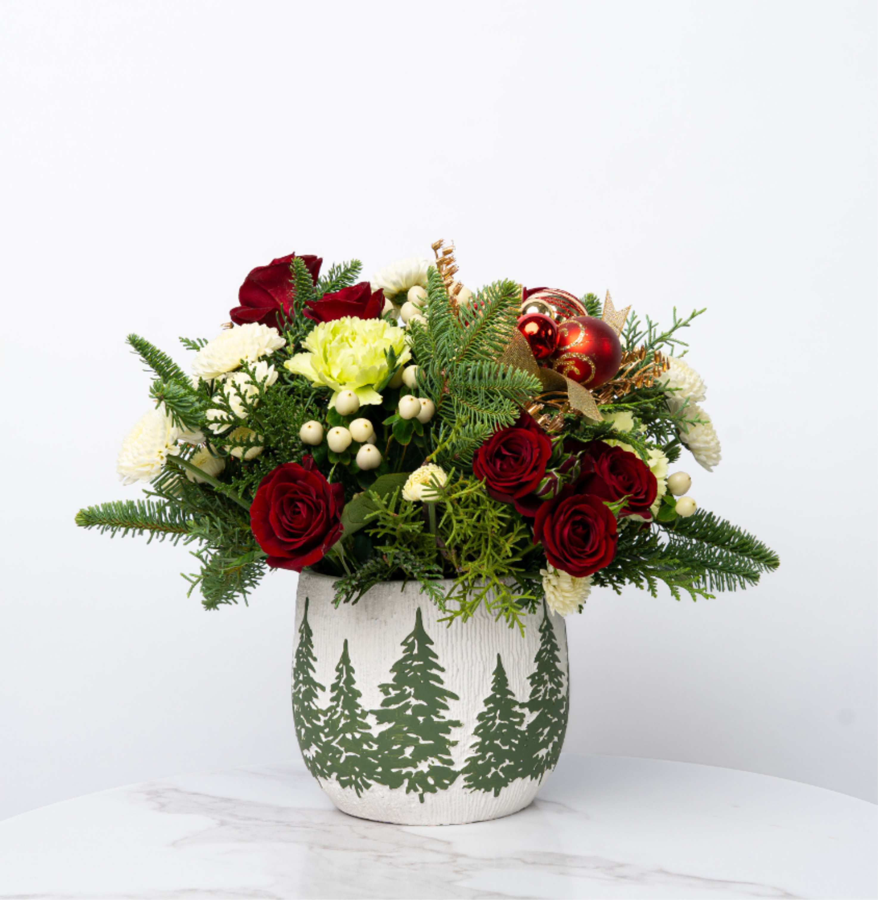 Red roses and white flowers in a holiday vase with ornaments