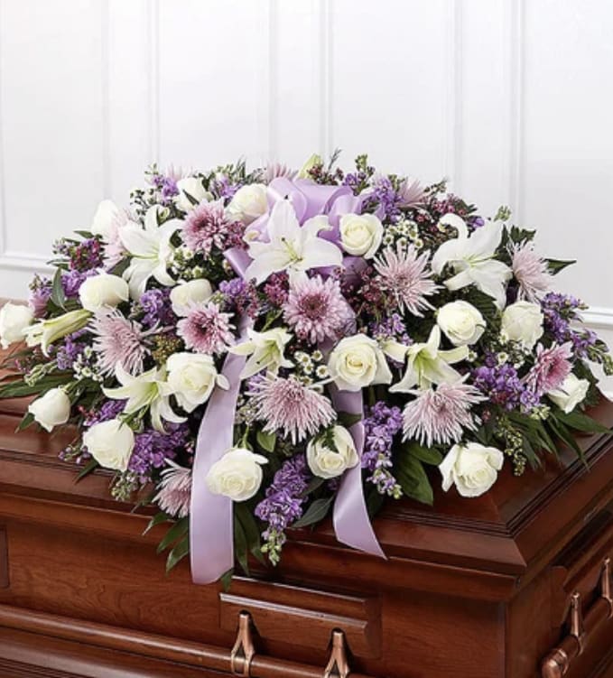 Lavender and white floral casket spray with ribbon accents
